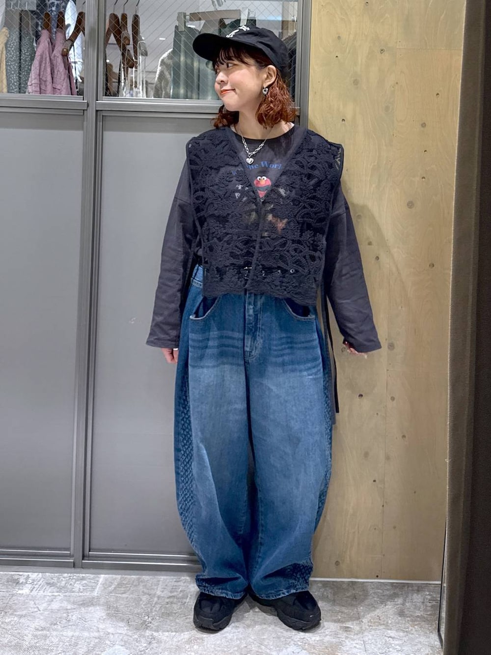 グレー系のTシャツ/カットソー、ブルー系のデニムパンツ、ブラック系のベストを着用したレディースの冬コーディネートの6枚目の写真