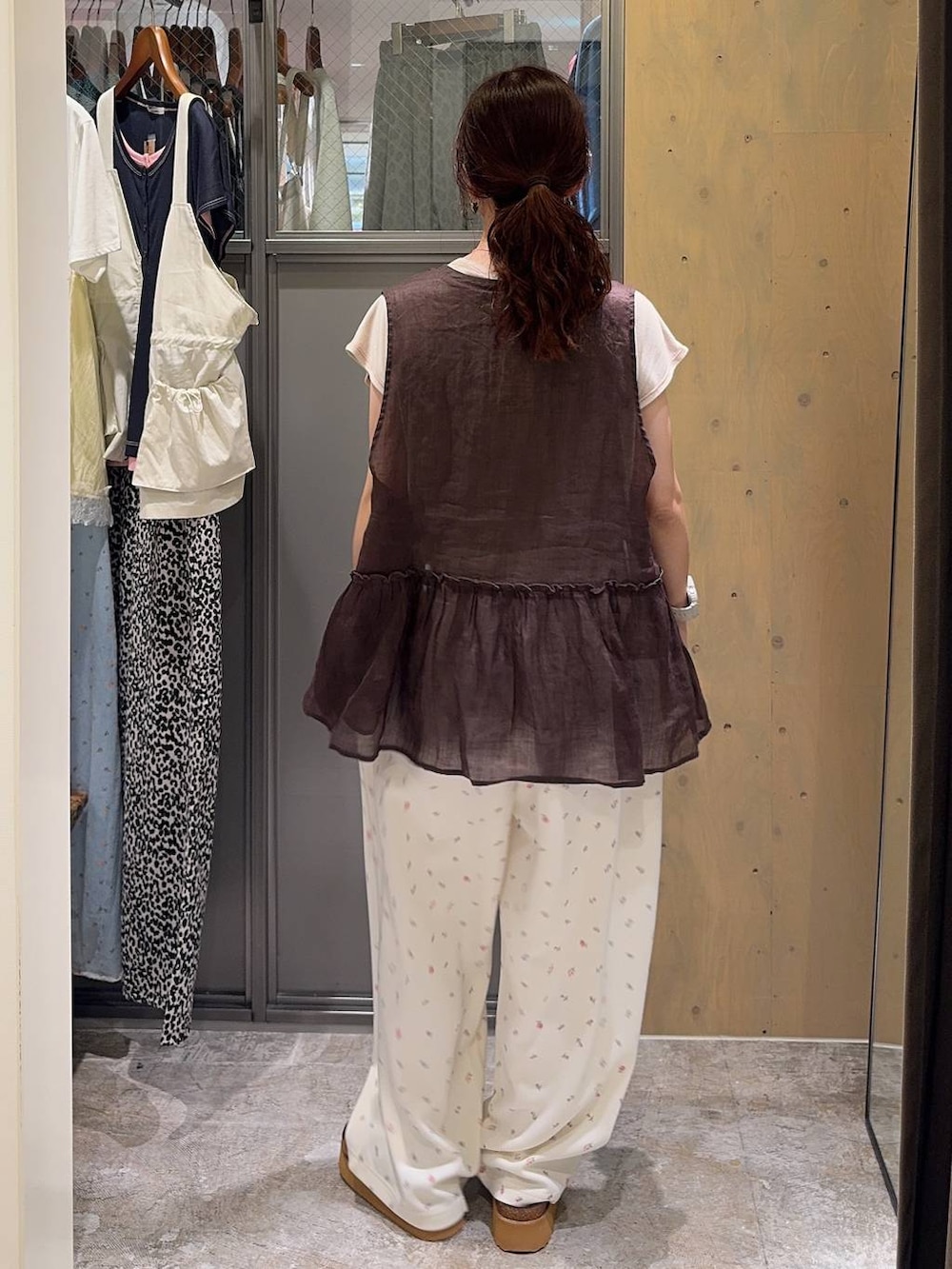 ブラウン系のベスト、ブラウン系のサンダル、ベージュ系のTシャツ/カットソーを着用したレディースの夏コーディネートの4枚目の写真
