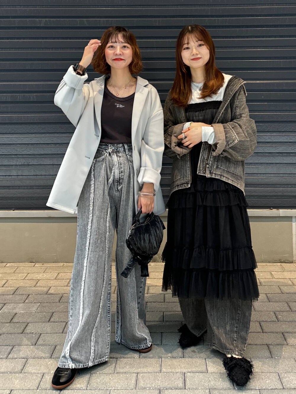 グレー系のTシャツ/カットソー、ブラック系のスカート、グレー系のデニムパンツを着用したレディースの秋コーディネートの6枚目の写真