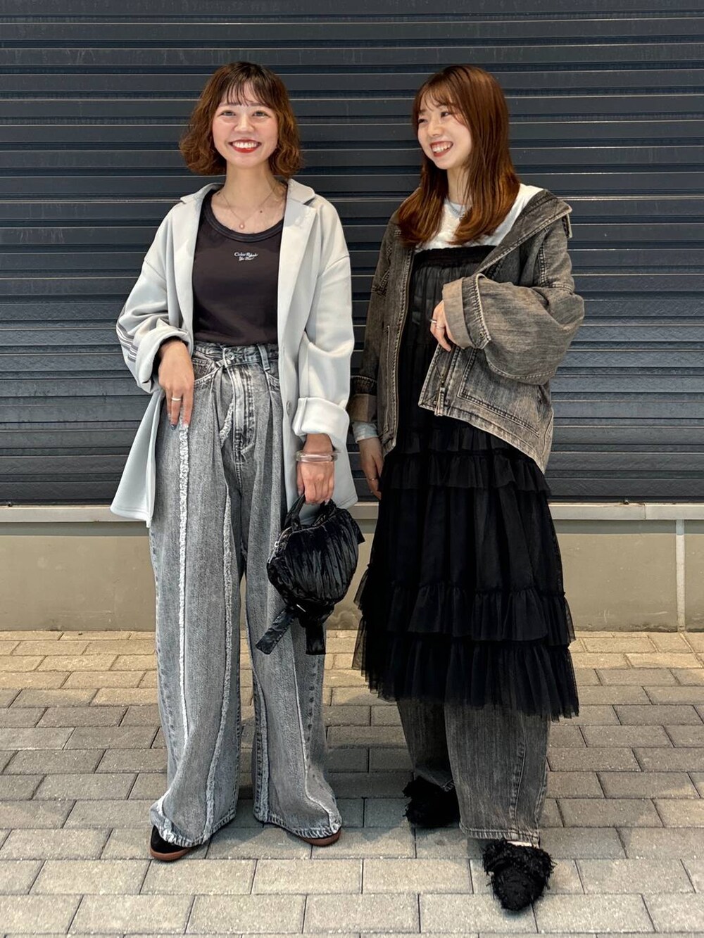 グレー系のTシャツ/カットソー、ブラック系のスカート、グレー系のデニムパンツを着用したレディースの秋コーディネートの2枚目の写真