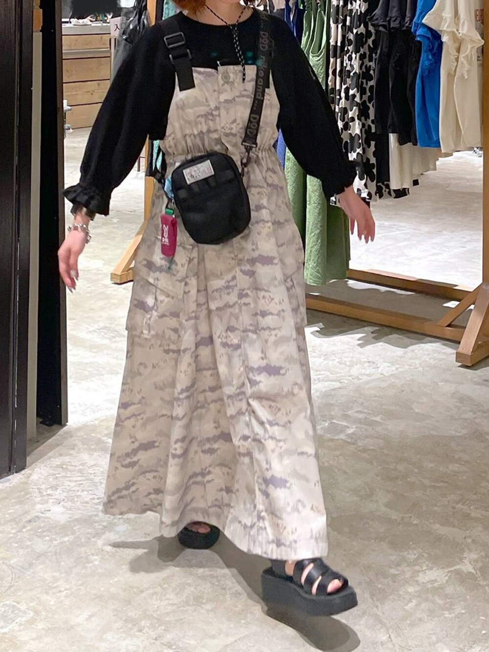 ブラック系のサンダル、ブラック系のTシャツ/カットソー、グリーン系のジャンパースカートを着用したレディースの春コーディネートの3枚目の写真