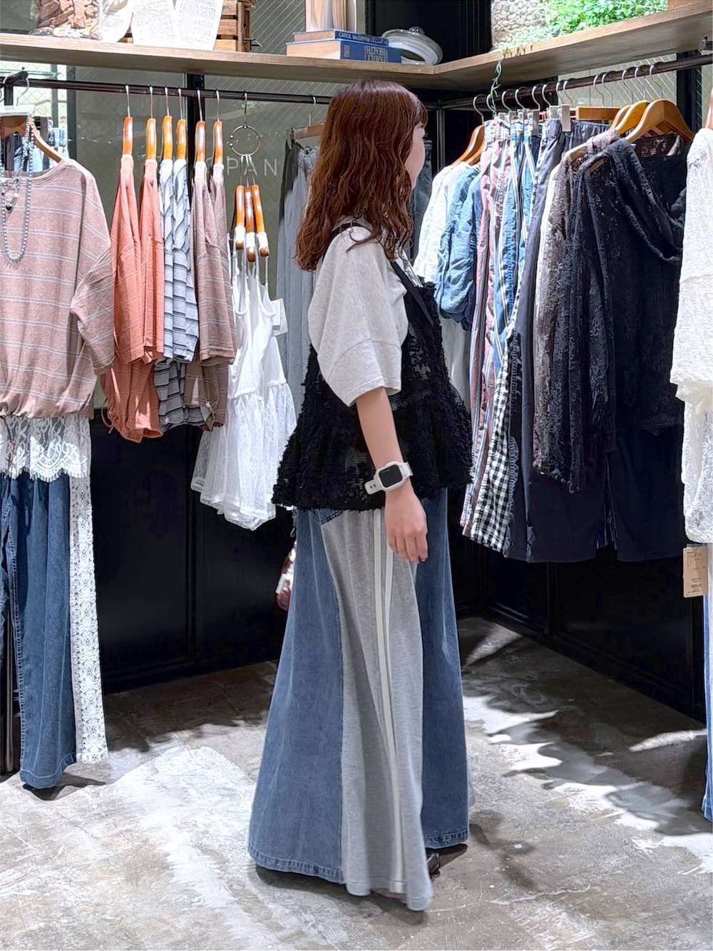 ブラック系のベスト、ベージュ系のTシャツ/カットソー、ブルー系のデニムスカートを着用したレディースの夏コーディネートの6枚目の写真