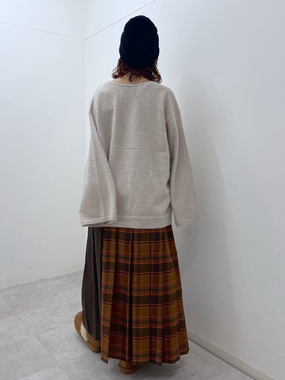 オレンジ系のスカート、ベージュ系のニット/セーター、イエロー系のその他シューズを着用したレディースの冬コーディネートの7枚目の写真