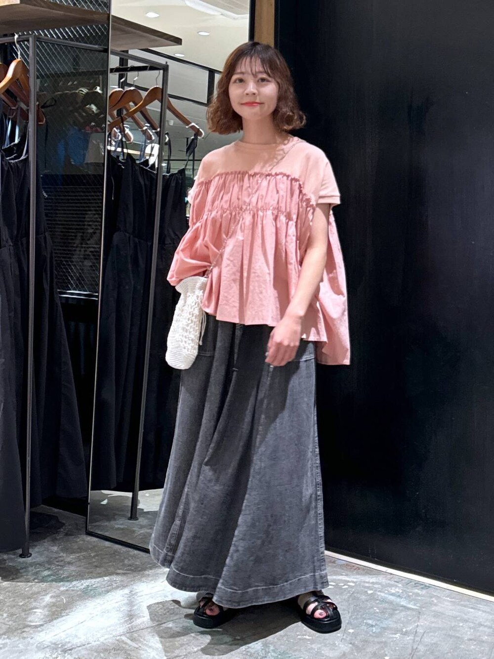 ホワイト系のショルダーバッグ、ブラック系のサンダル、グレー系のスカートを着用したレディースの夏コーディネートの6枚目の写真