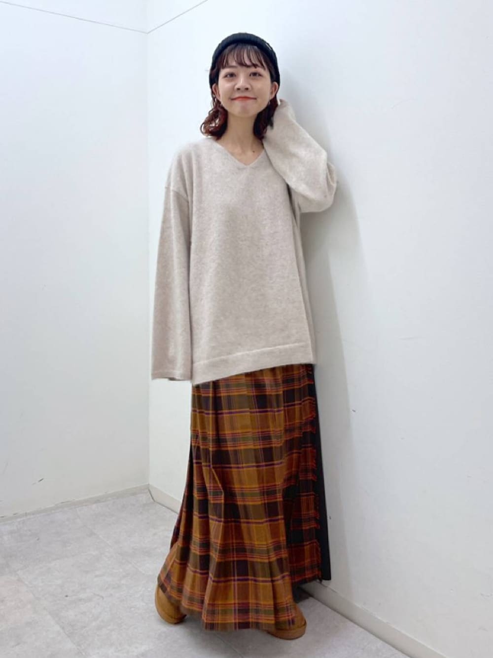 オレンジ系のスカート、ベージュ系のニット/セーター、イエロー系のその他シューズを着用したレディースの冬コーディネートの3枚目の写真