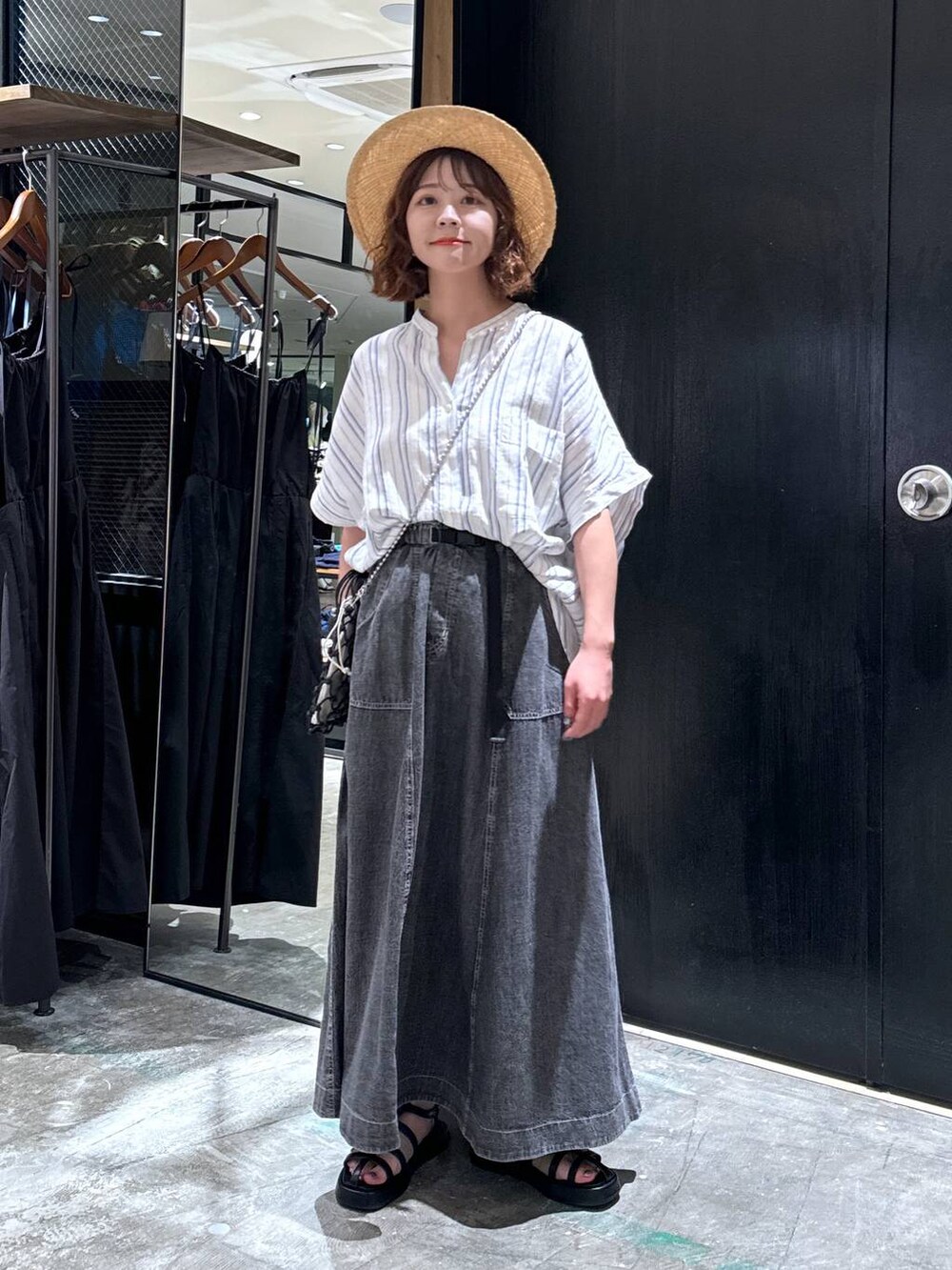 ブラック系のショルダーバッグ、ブラック系のサンダル、ベージュ系のシャツ/ブラウスを着用したレディースの夏コーディネートの6枚目の写真