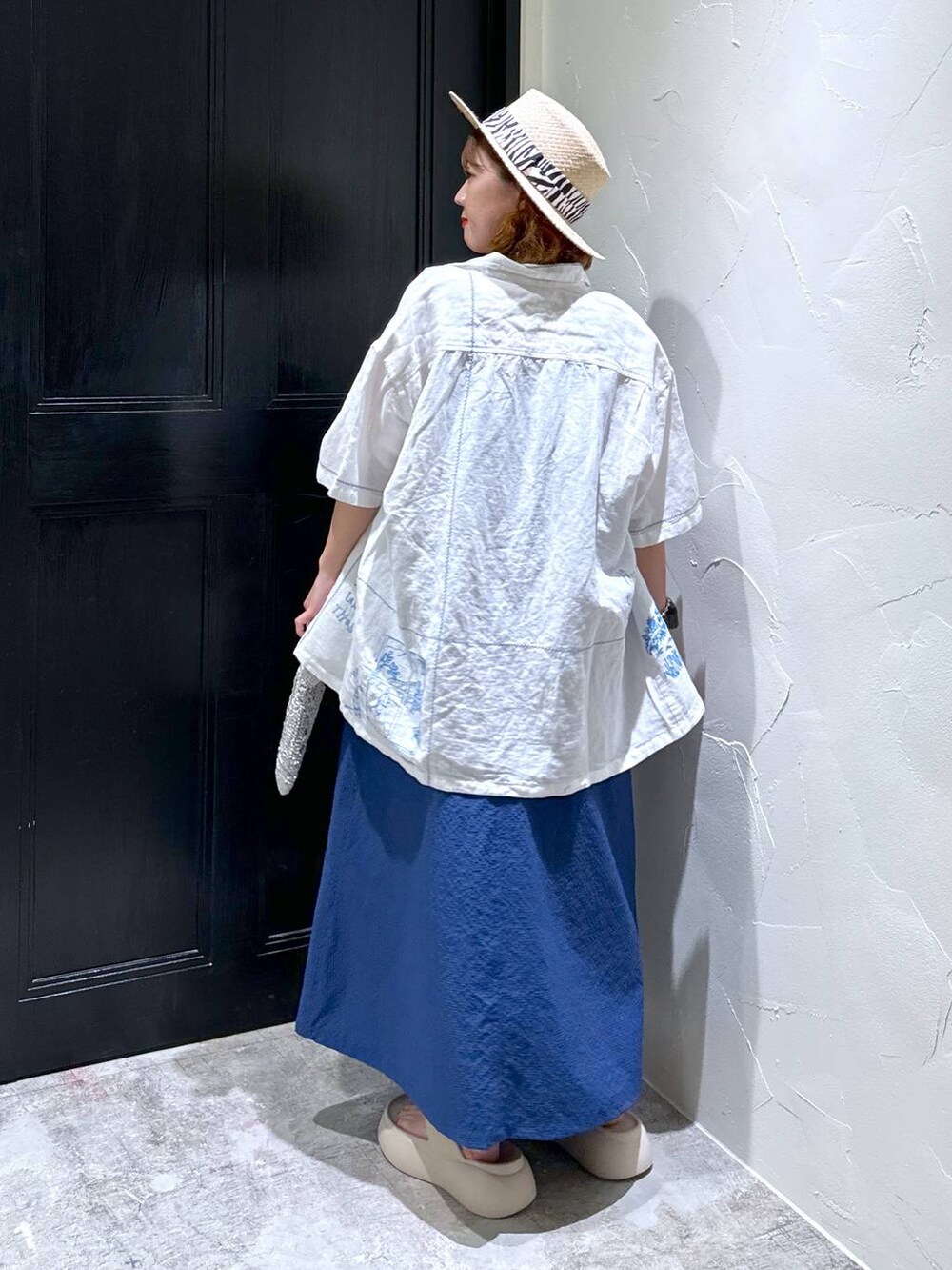 グレー系のショルダーバッグ、ベージュ系のサンダル、ブルー系のジャンパースカートを着用したレディースの夏コーディネートの6枚目の写真