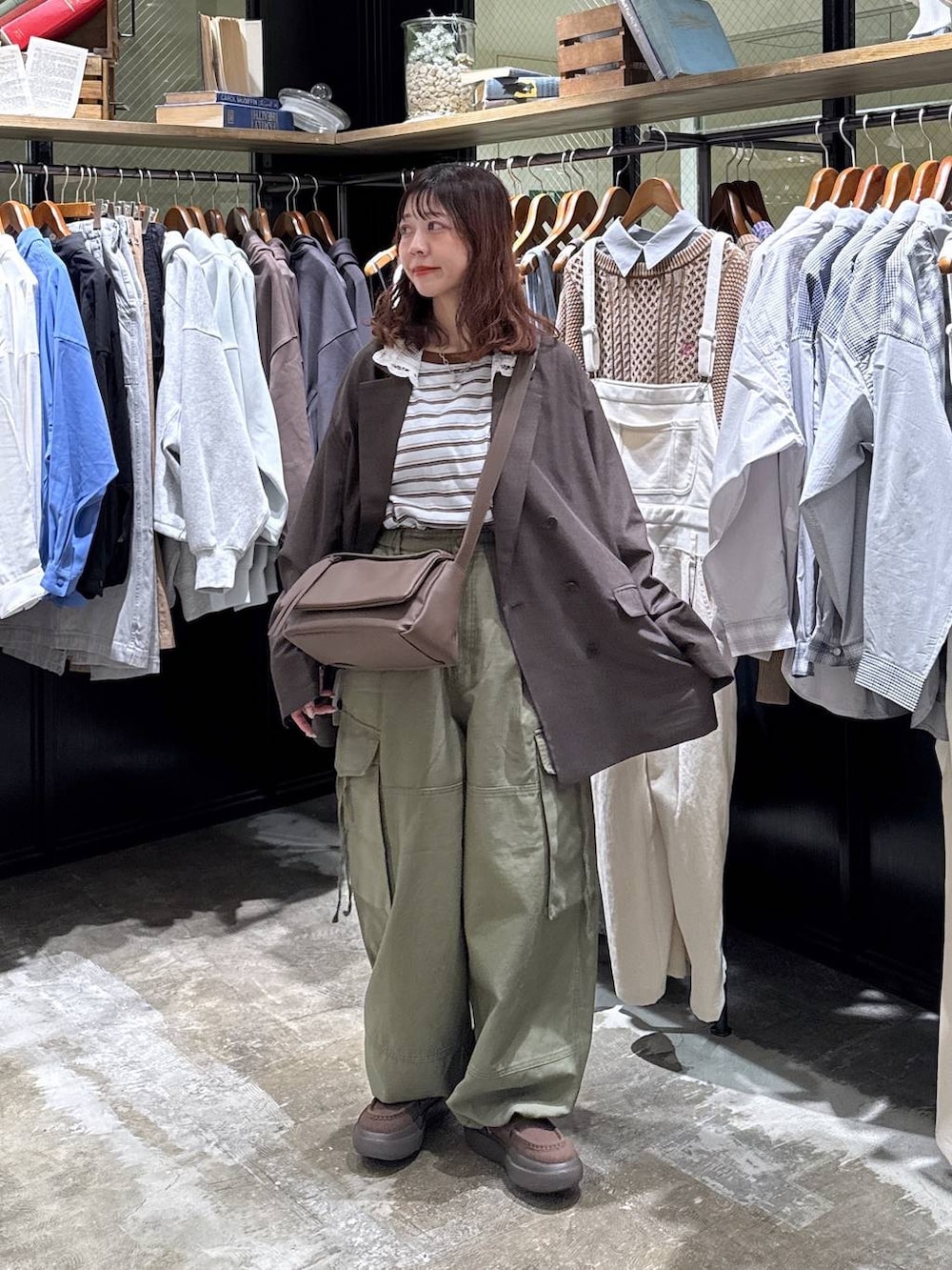 ブラウン系のショルダーバッグ、グリーン系のカーゴパンツ、ブルー系のTシャツ/カットソーを着用したレディースの冬コーディネートの2枚目の写真