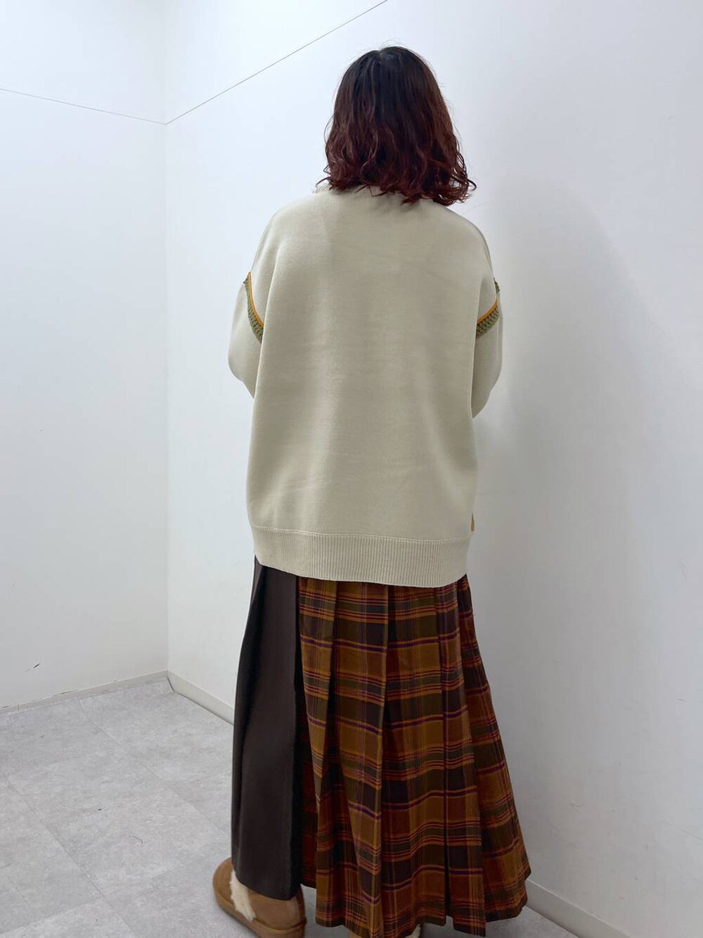 オレンジ系のスカート、ベージュ系のニット/セーター、イエロー系のその他シューズを着用したレディースの冬コーディネートの4枚目の写真