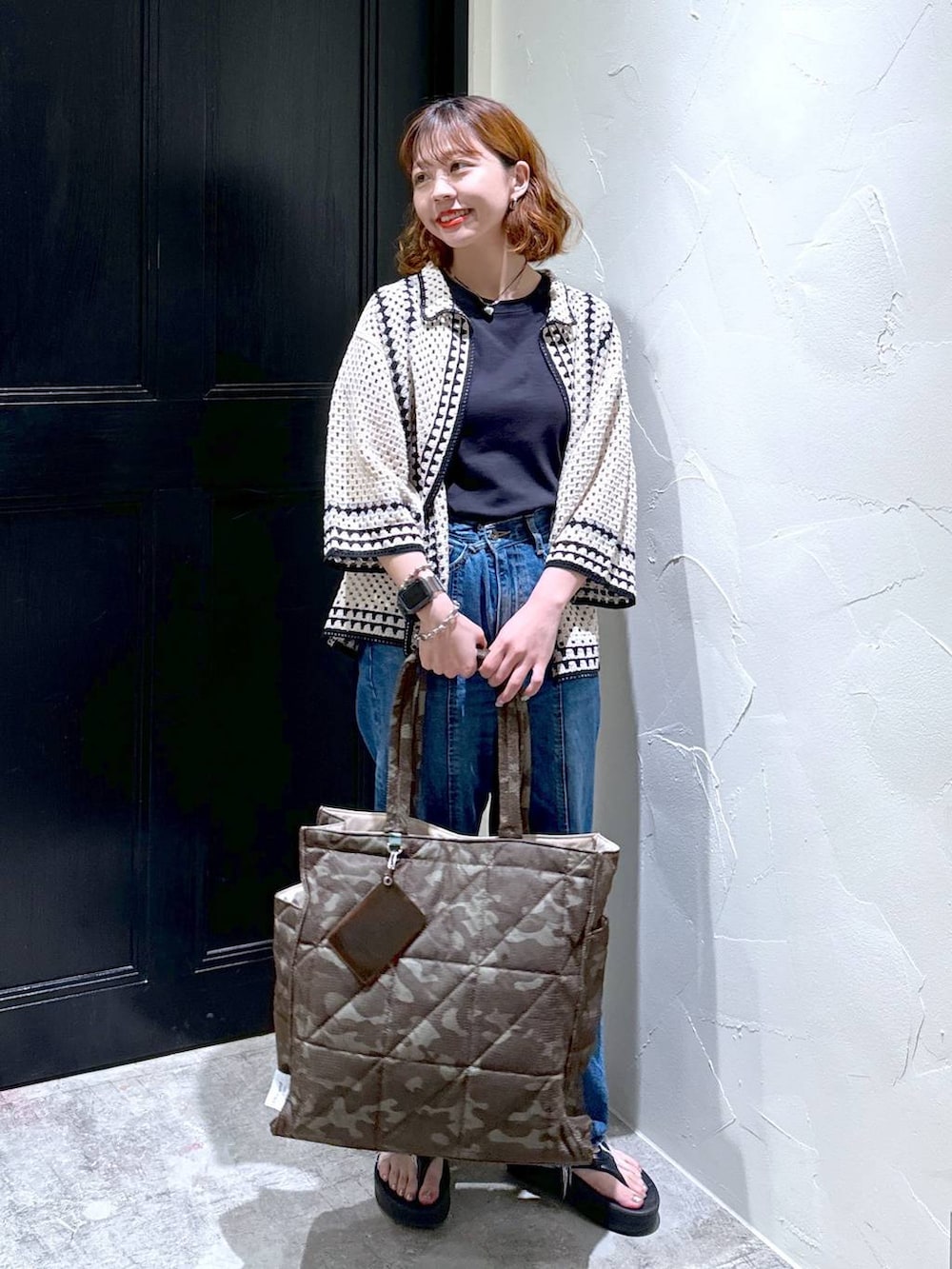 ブラック系のTシャツ/カットソー、ブラック系のサンダル、ブルー系のデニムパンツを着用したレディースの夏コーディネートの2枚目の写真