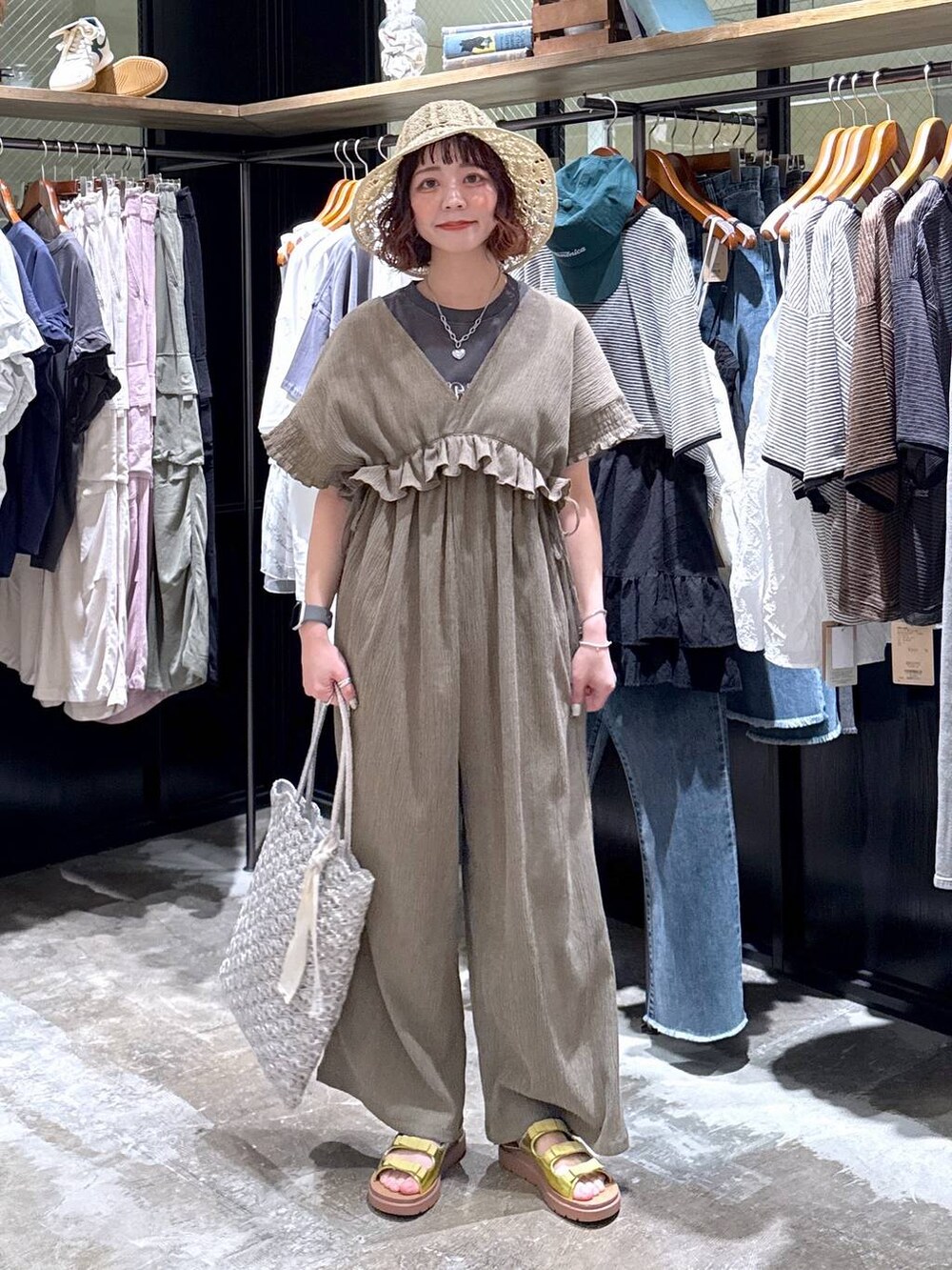 イエロー系のサンダル、シルバー系のトートバッグ、グリーン系のサロペット/オーバーオールを着用したレディースの春コーディネートの7枚目の写真