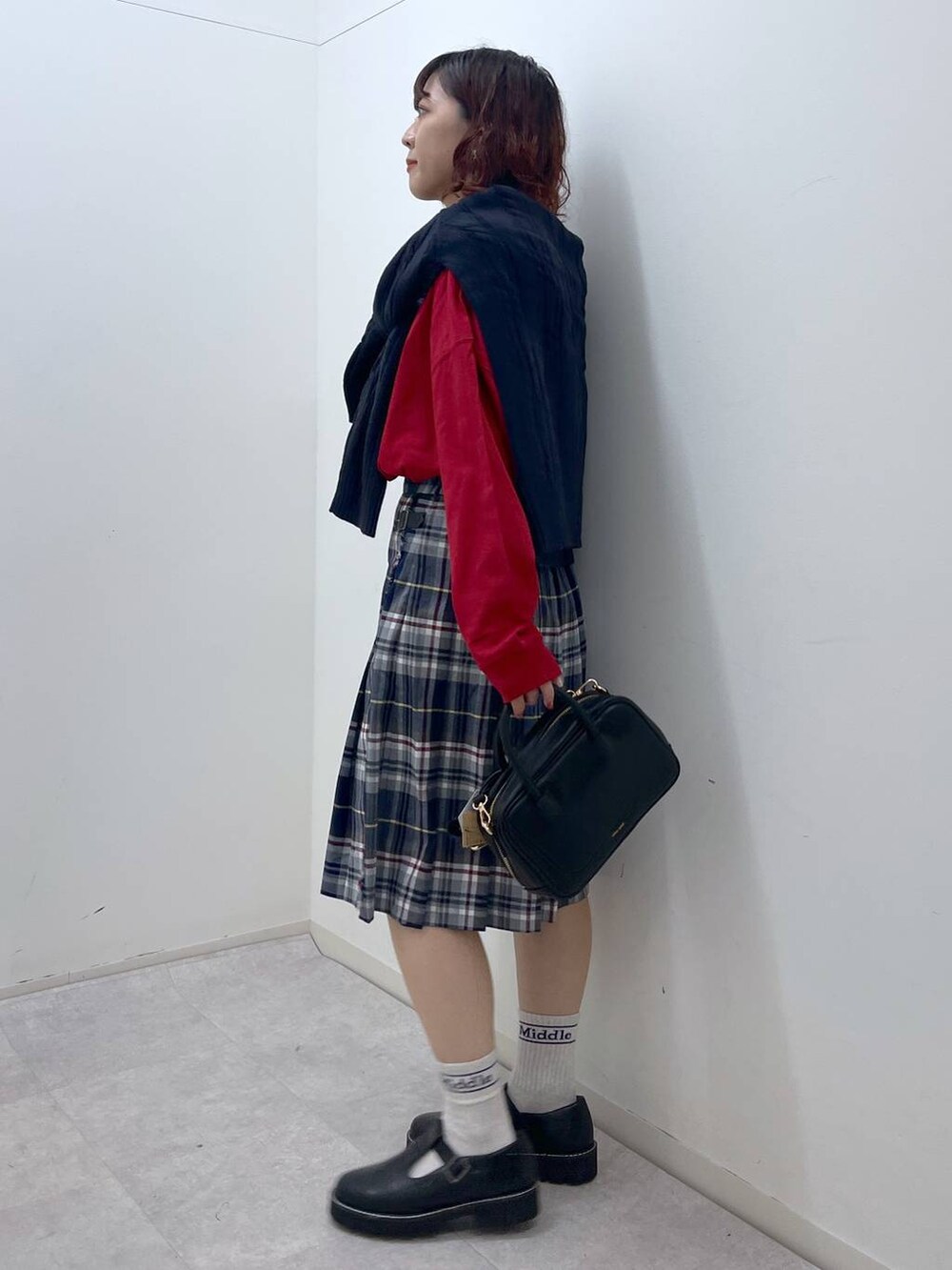 ブラック系のその他シューズ、ブラック系のショルダーバッグ、レッド系のTシャツ/カットソーを着用したレディースの冬コーディネートの5枚目の写真