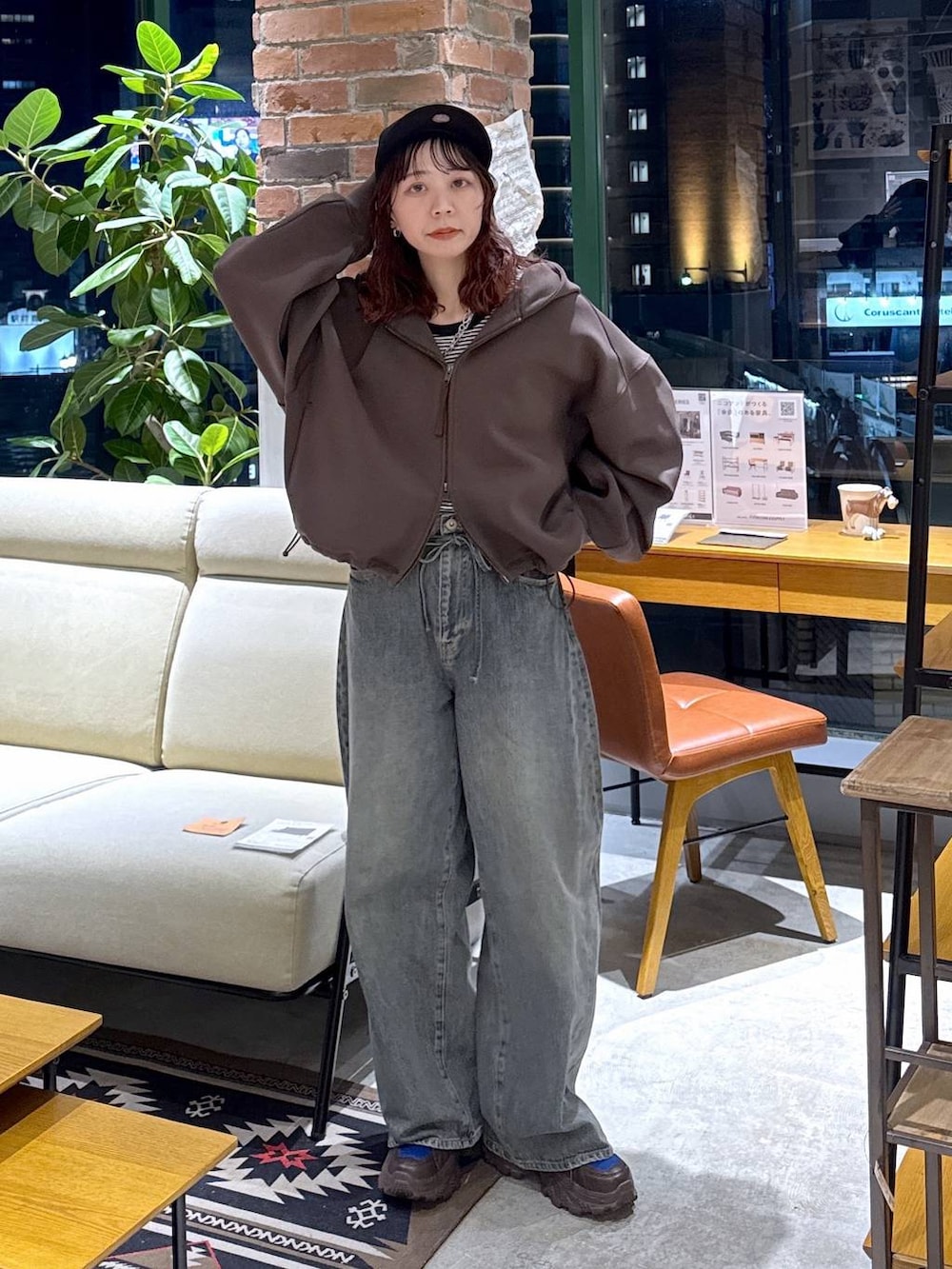 ブラウン系のスニーカー、ブルー系のデニムパンツ、ブラウン系のパーカーを着用したレディースの冬コーディネートの9枚目の写真