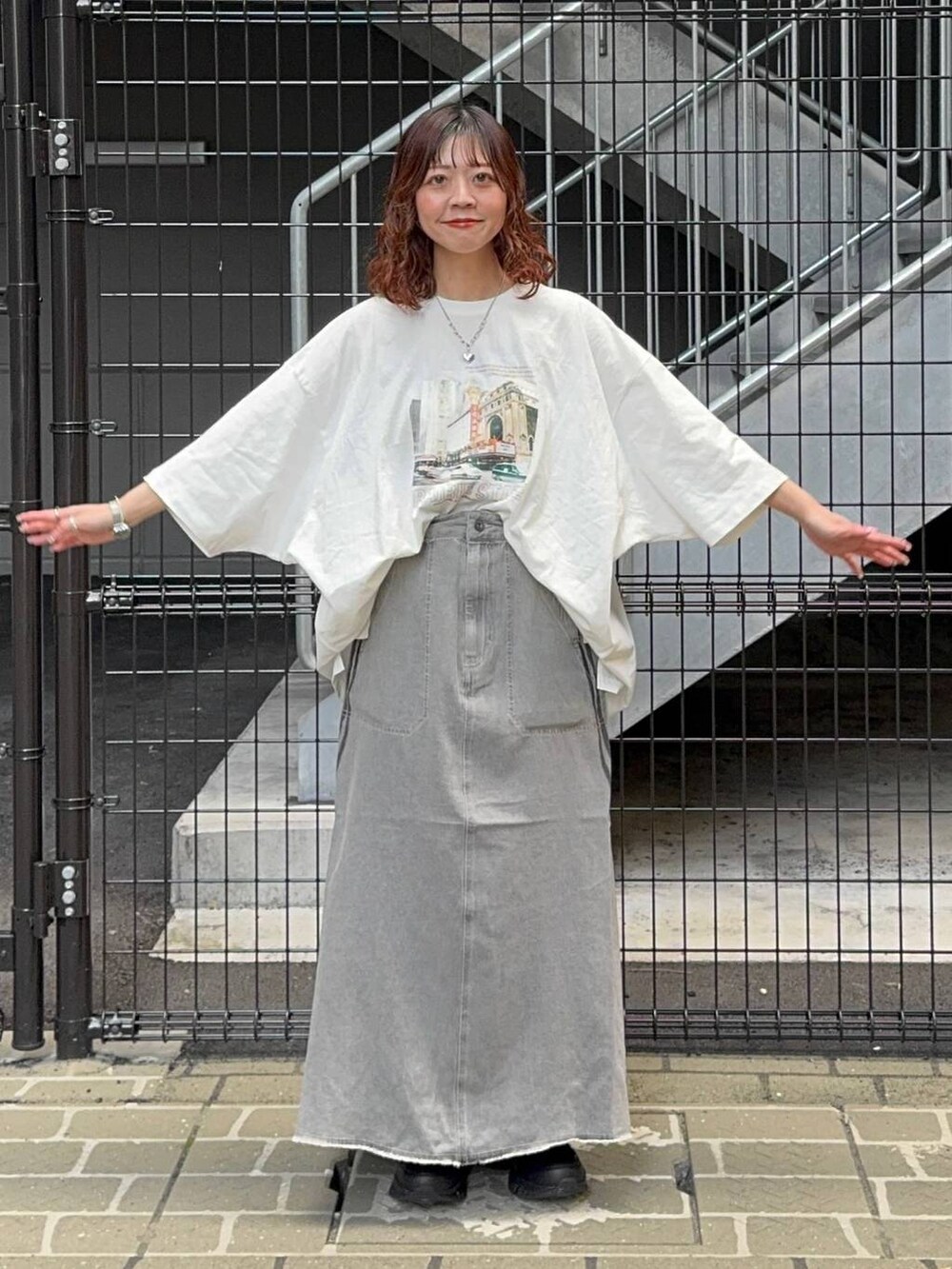 グリーン系のシャツ/ブラウス、オレンジ系のバックパック/リュック、ホワイト系のTシャツ/カットソーを着用したレディースの春コーディネートの6枚目の写真