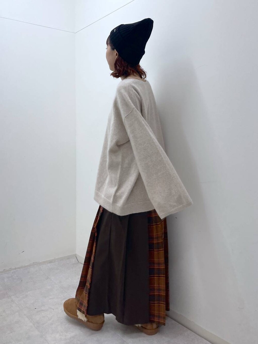 オレンジ系のスカート、ベージュ系のニット/セーター、イエロー系のその他シューズを着用したレディースの冬コーディネートの6枚目の写真