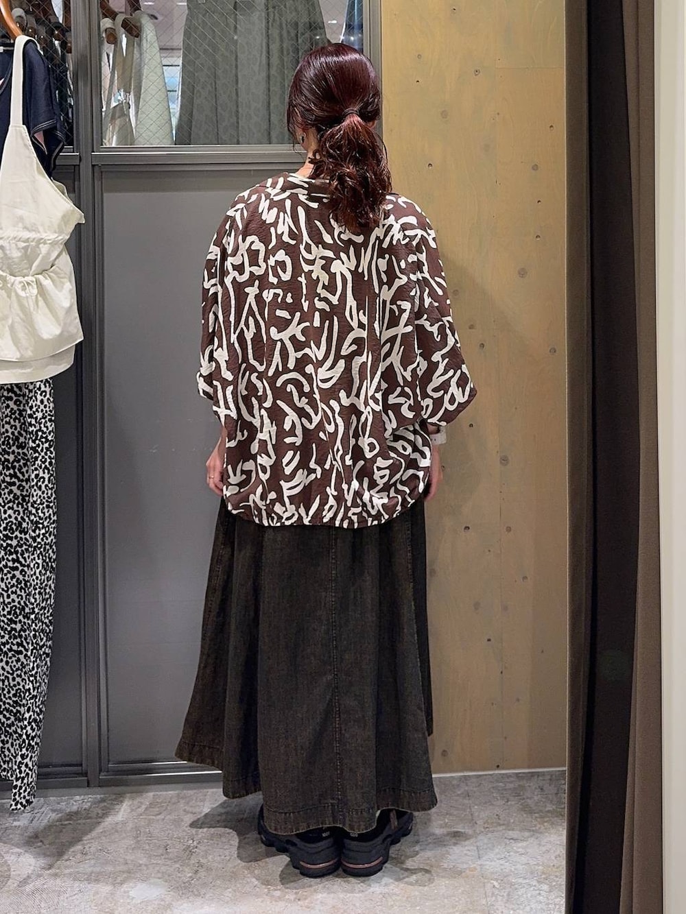 ブラウン系のスカート、ブラウン系のシャツ/ブラウス、ホワイト系のTシャツ/カットソーを着用したレディースの春コーディネートの3枚目の写真