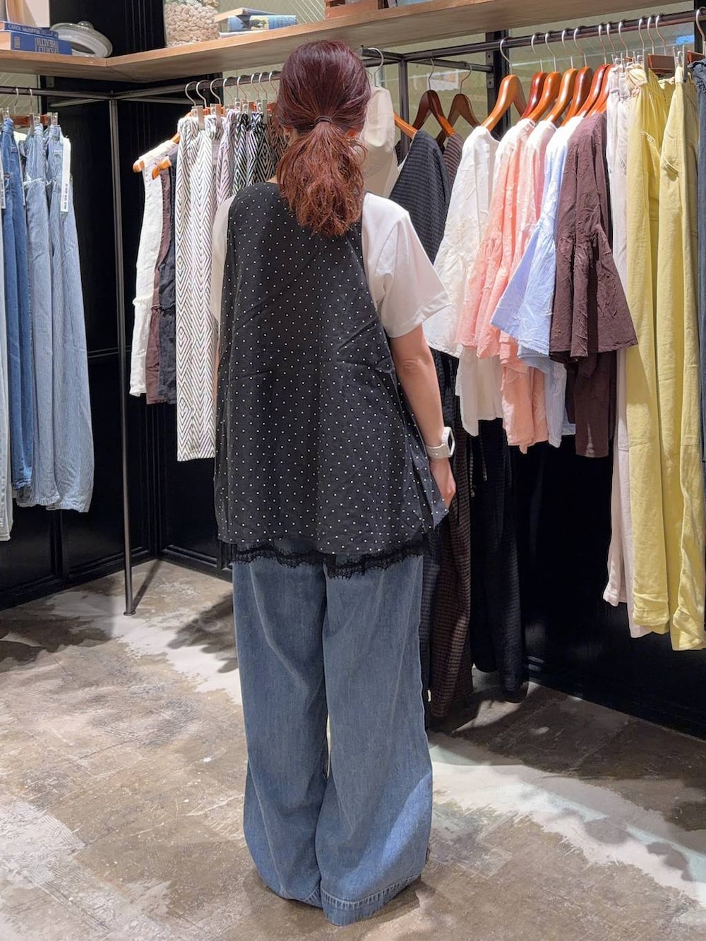 ブラック系のスニーカー、ブラック系のベスト、ホワイト系のTシャツ/カットソーを着用したレディースの夏コーディネートの4枚目の写真