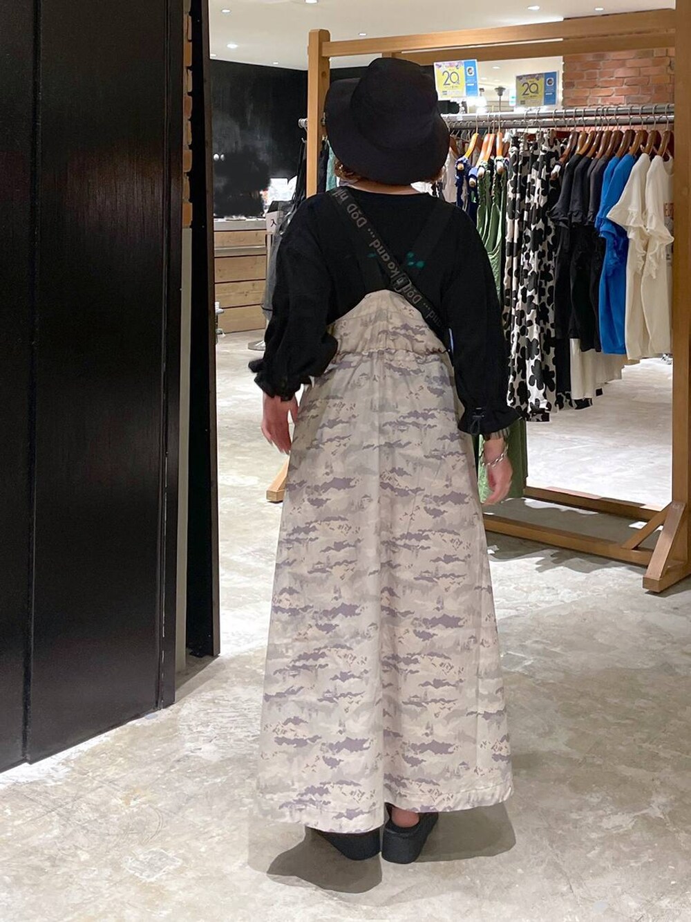 ブラック系のサンダル、ブラック系のTシャツ/カットソー、グリーン系のジャンパースカートを着用したレディースの春コーディネートの5枚目の写真