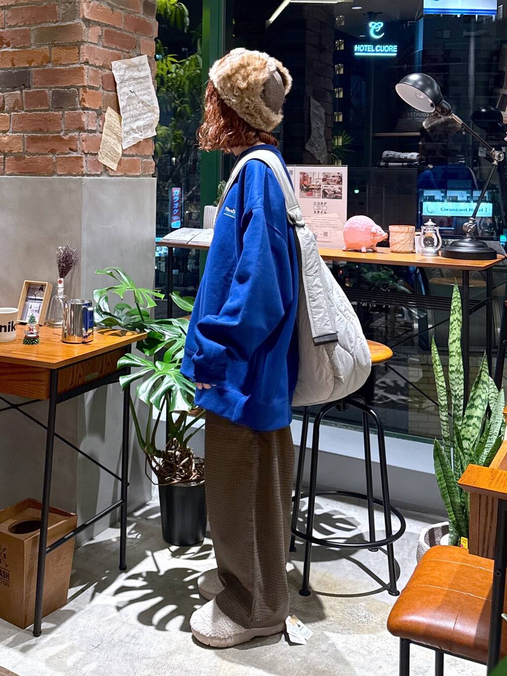 ブラウン系のその他パンツ、ブルー系のスウェット、ホワイト系のショルダーバッグを着用したレディースの冬コーディネートの2枚目の写真