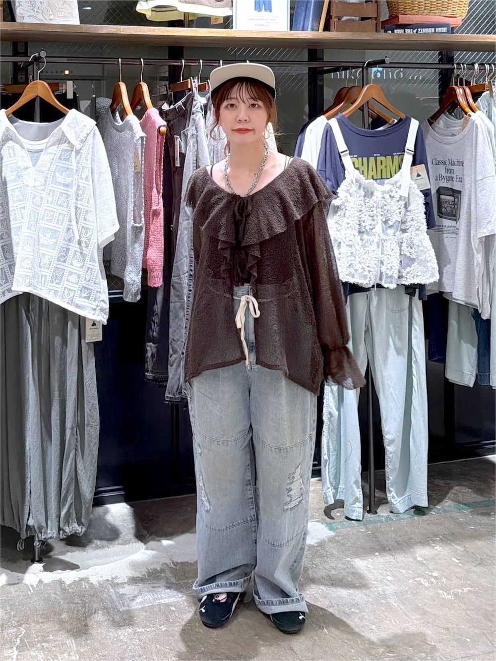 ブラウン系のカーディガン/ボレロ、ブルー系のデニムパンツ、ブラック系のキャップを着用したレディースの秋コーディネートの2枚目の写真