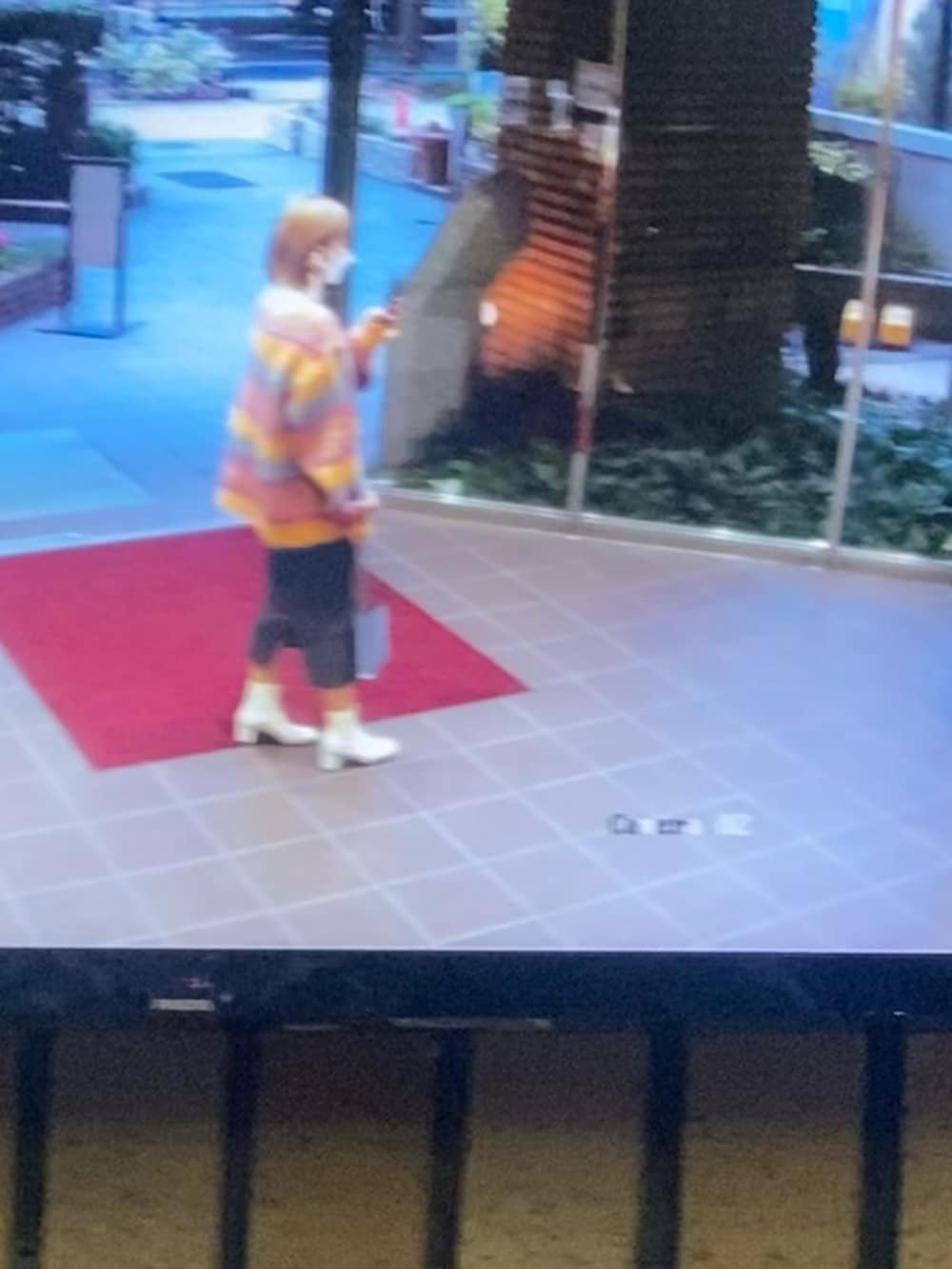 ホワイト系のニット/セーター、ブルー系のショルダーバッグ、オレンジ系のカーディガン/ボレロを着用したレディースの冬コーディネートの2枚目の写真