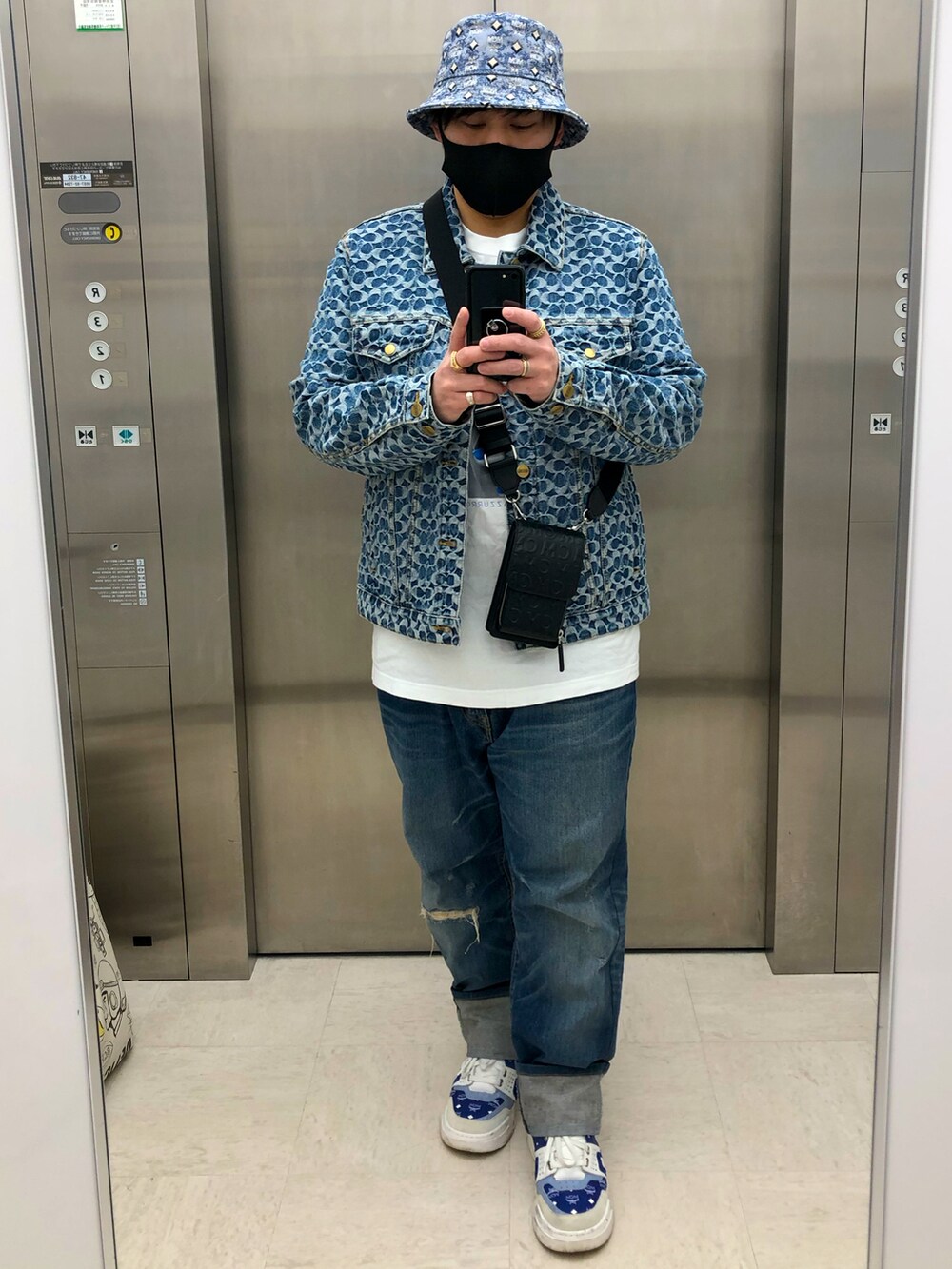 ブルー系のデニムジャケット、ブラック系のショルダーバッグ、ブルー系のデニムパンツを着用したメンズの春コーディネートの2枚目の写真