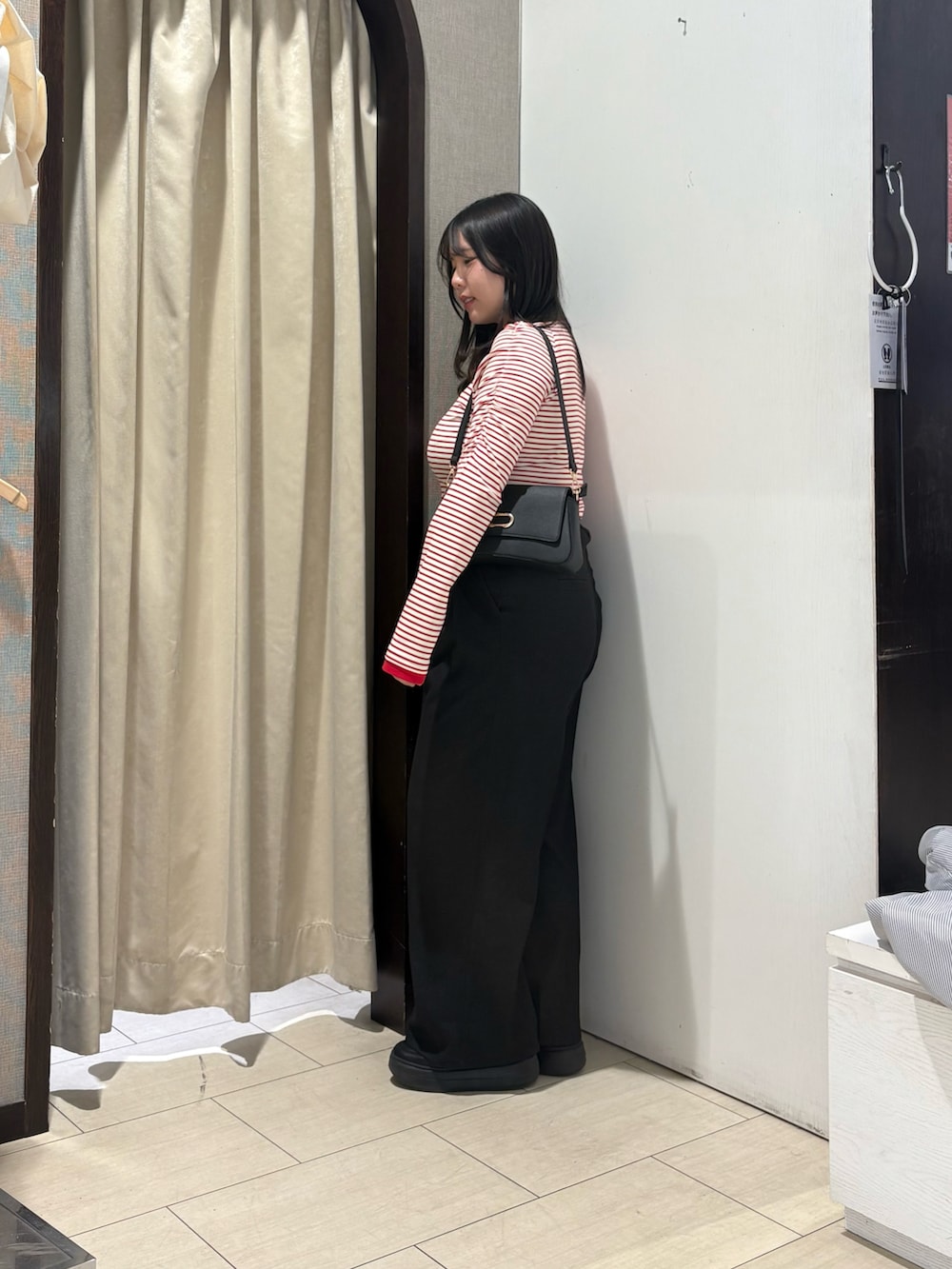 レッド系のTシャツ/カットソー、ブラック系のショルダーバッグ、ブラウン系のその他パンツを着用したレディースの春コーディネートの2枚目の写真