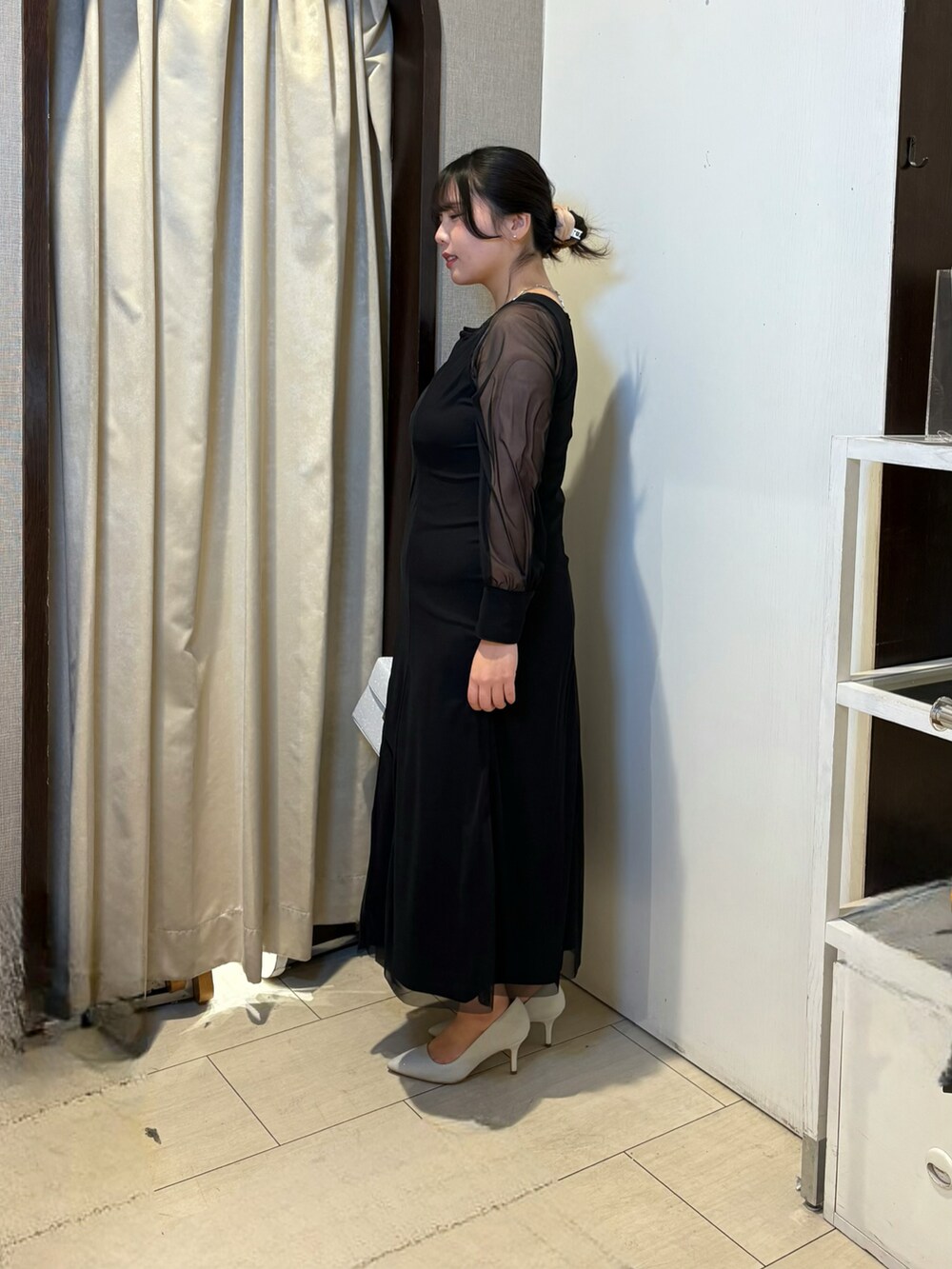 ブラック系のワンピース、シルバー系のパンプス、ホワイト系のその他アウターを着用したレディースの冬コーディネートの3枚目の写真