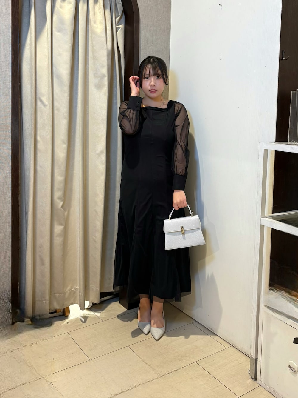 ブラック系のワンピース、シルバー系のパンプス、ホワイト系のその他アウターを着用したレディースの冬コーディネートの2枚目の写真