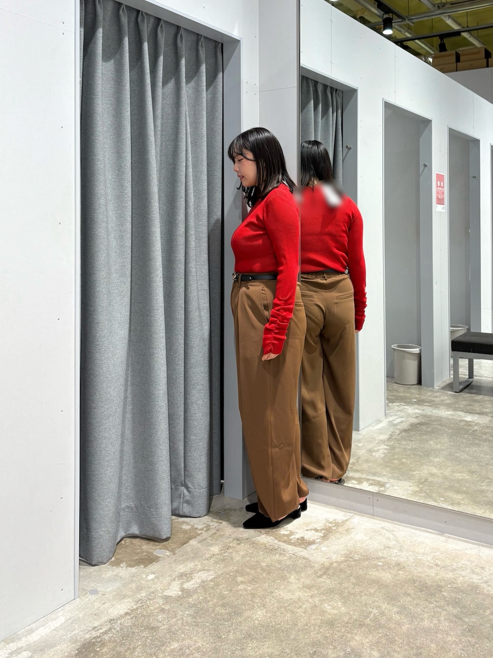 レッド系のニット/セーター、ブラウン系のその他パンツ、ブラック系のベルトを着用したレディースの秋コーディネートの2枚目の写真