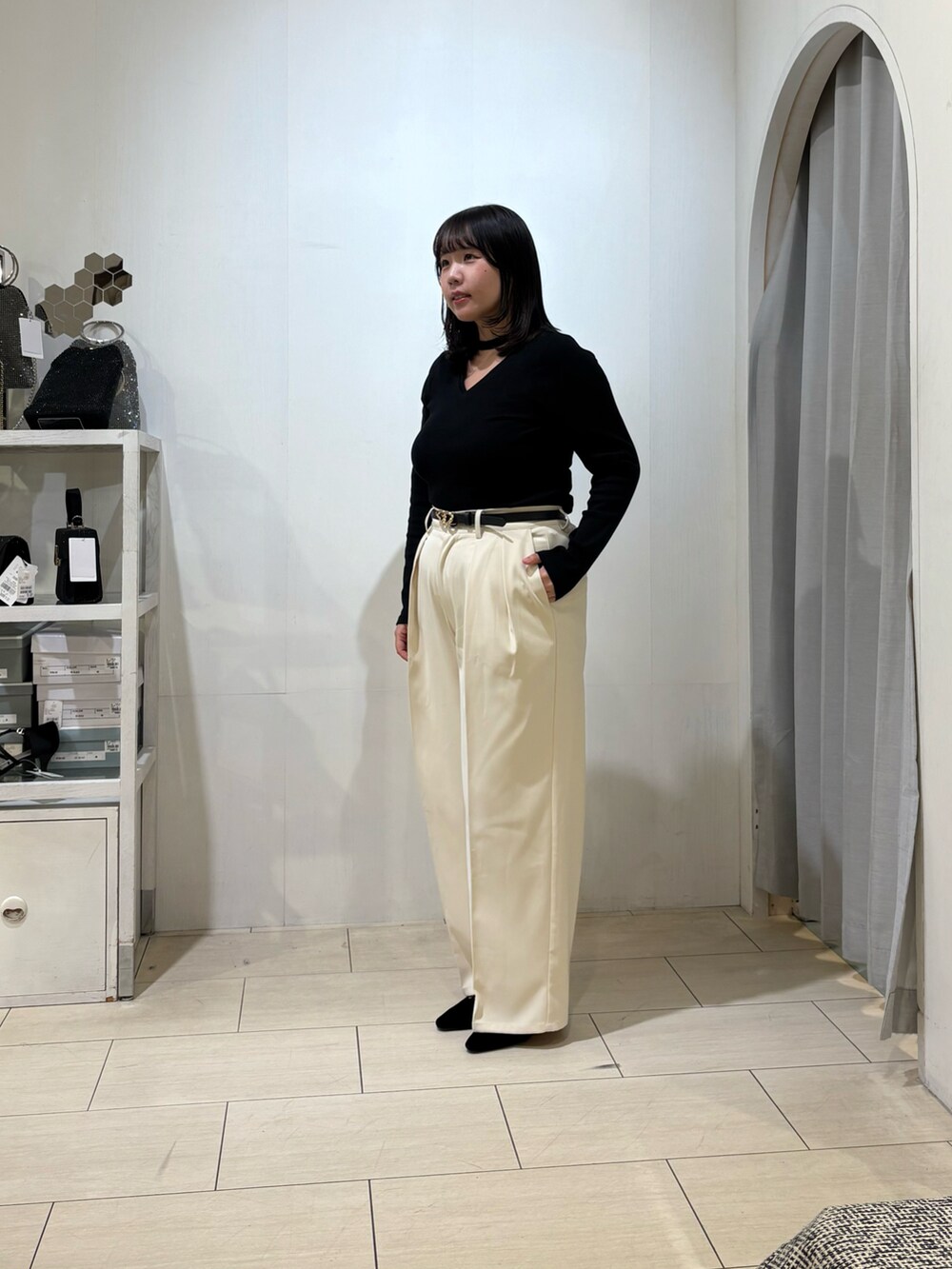 ホワイト系のスラックス、ブラック系のTシャツ/カットソー、ブラック系のベルトを着用したレディースの秋コーディネートの2枚目の写真