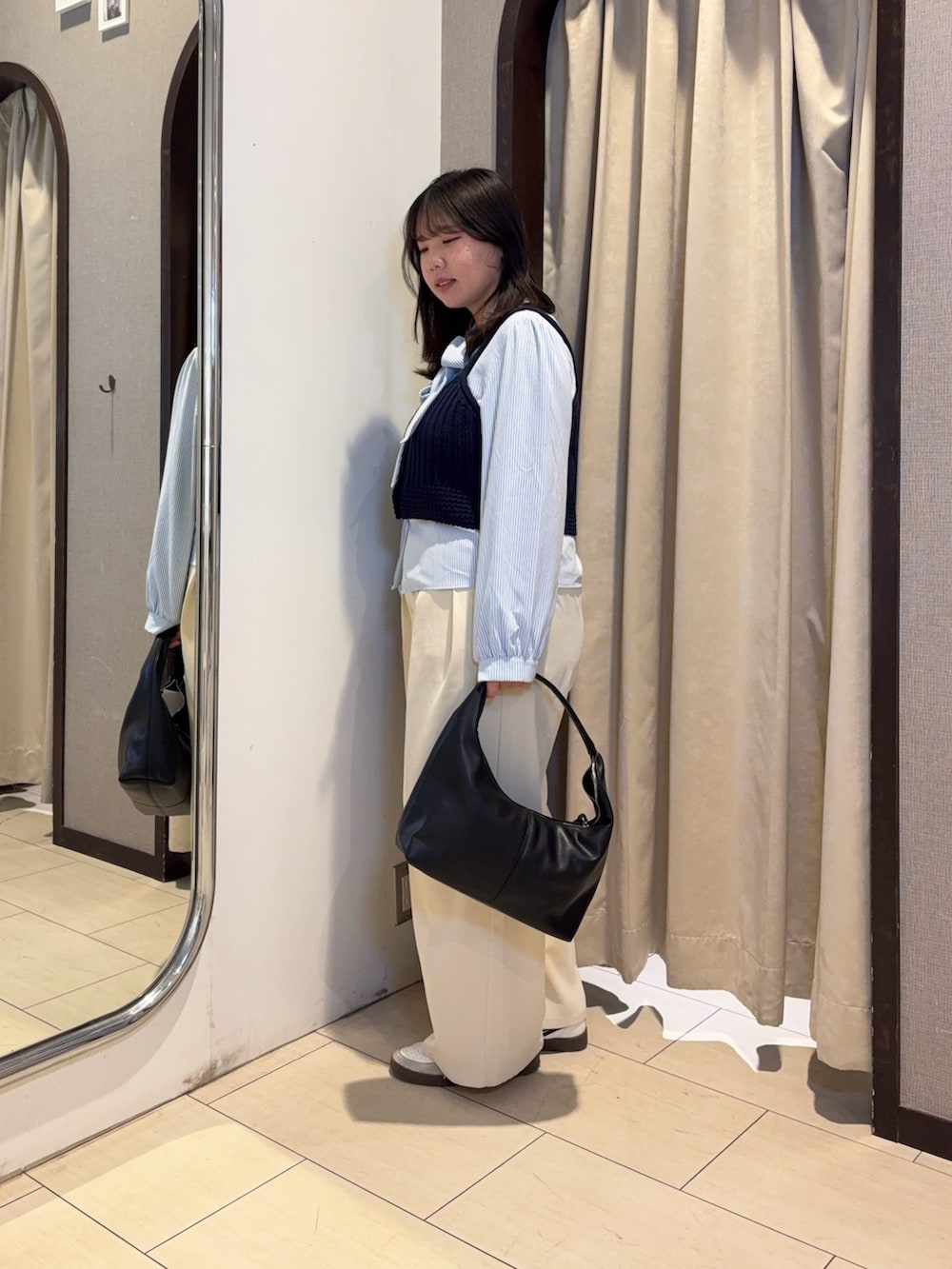 ブルー系のシャツ/ブラウス、ホワイト系のスラックス、ブラック系のベルトを着用したレディースの冬コーディネートの2枚目の写真