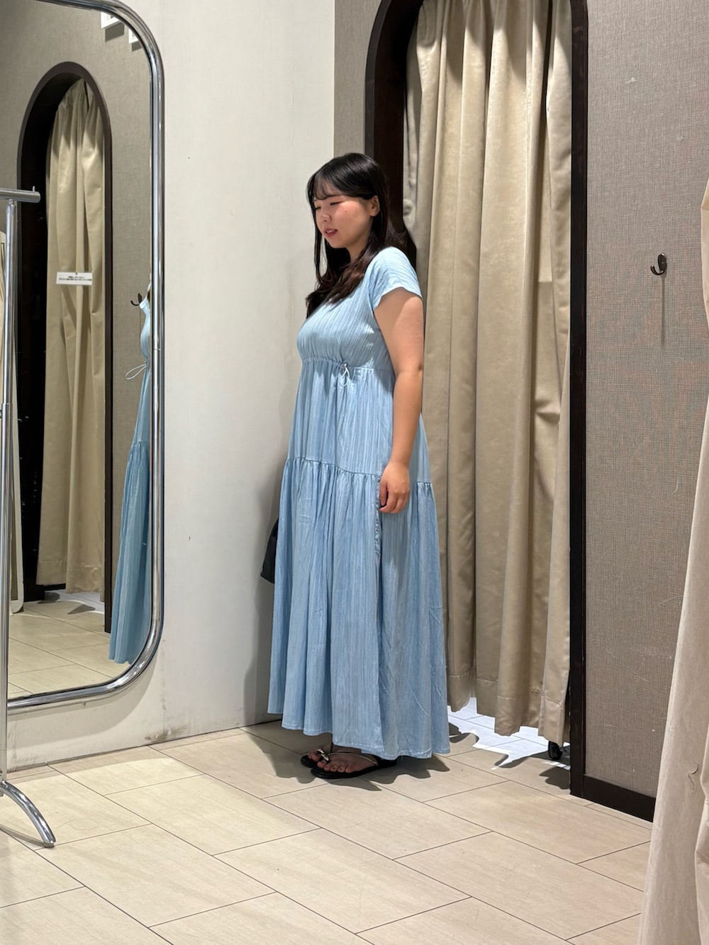 ブルー系のワンピース、ブラック系のサンダルを着用したレディースの夏コーディネートの2枚目の写真