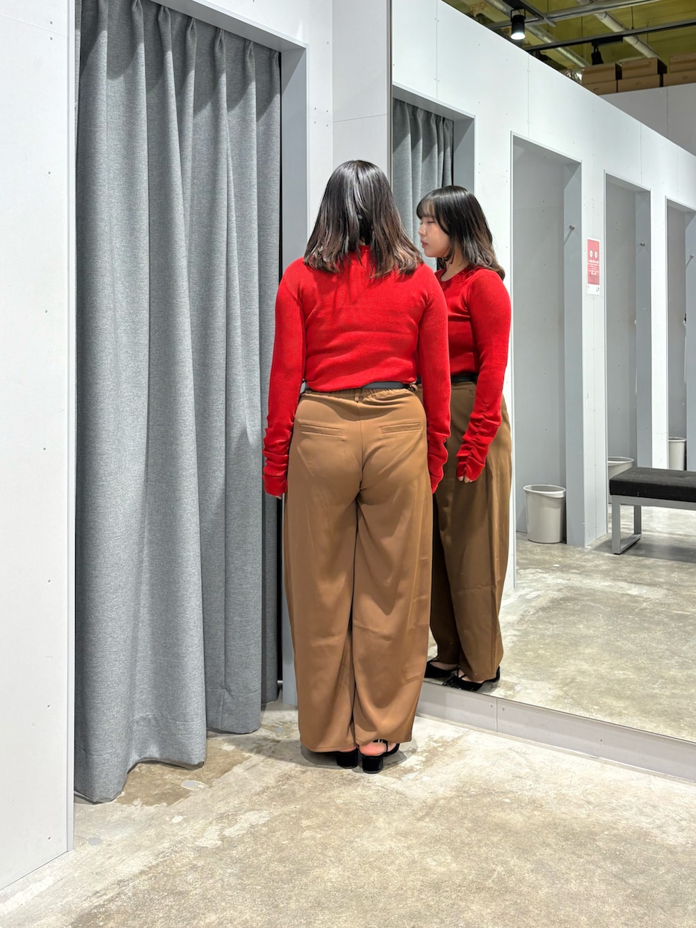 レッド系のニット/セーター、ブラウン系のその他パンツ、ブラック系のベルトを着用したレディースの秋コーディネートの3枚目の写真