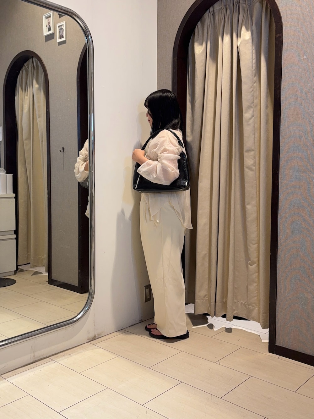 ホワイト系のスラックス、ホワイト系のシャツ/ブラウス、ブラック系のベルトを着用したレディースの夏コーディネートの2枚目の写真