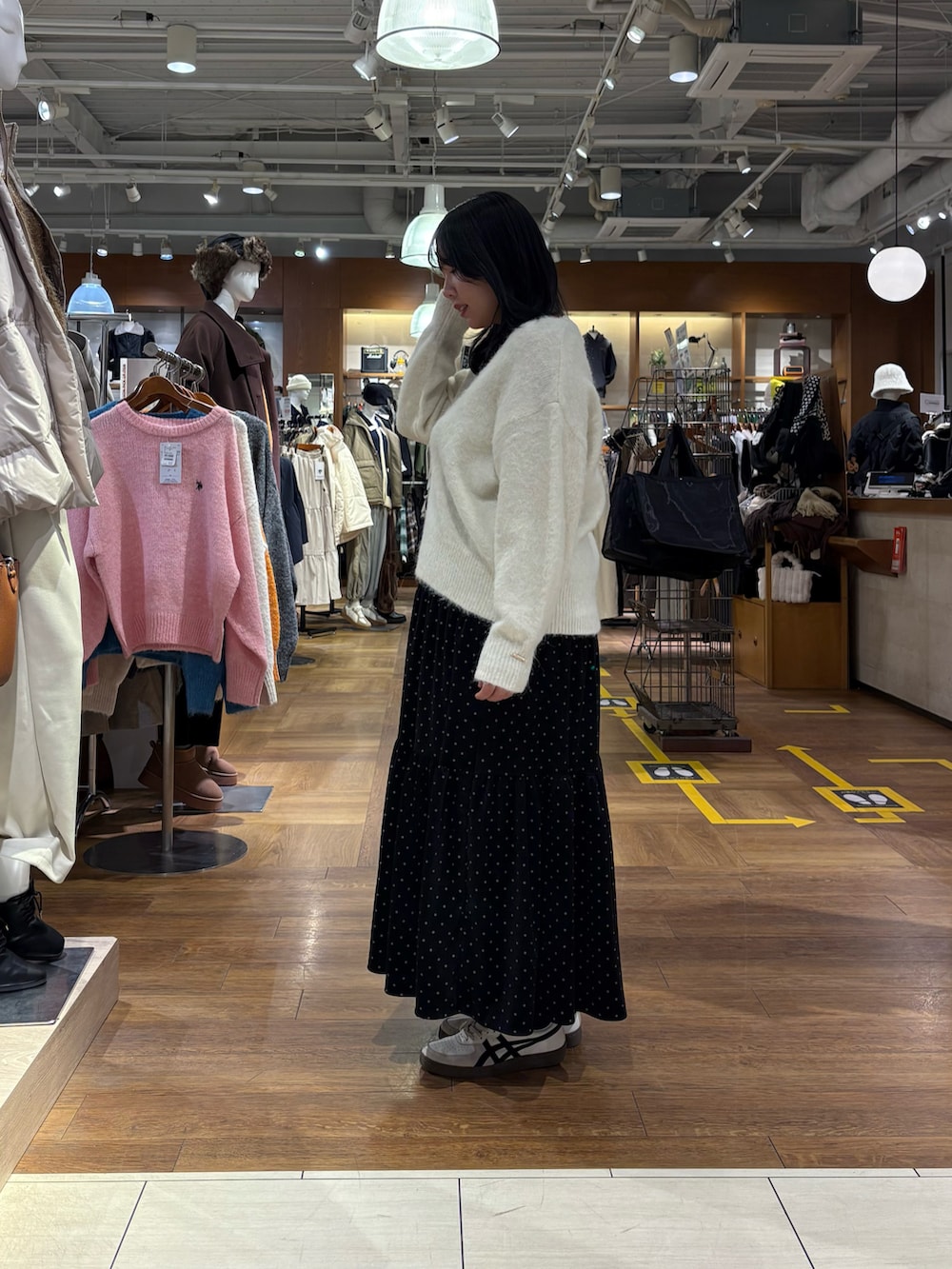 ブラック系のその他アウター、ホワイト系のニット/セーター、ブラック系のスカートを着用したレディースの冬コーディネートの2枚目の写真