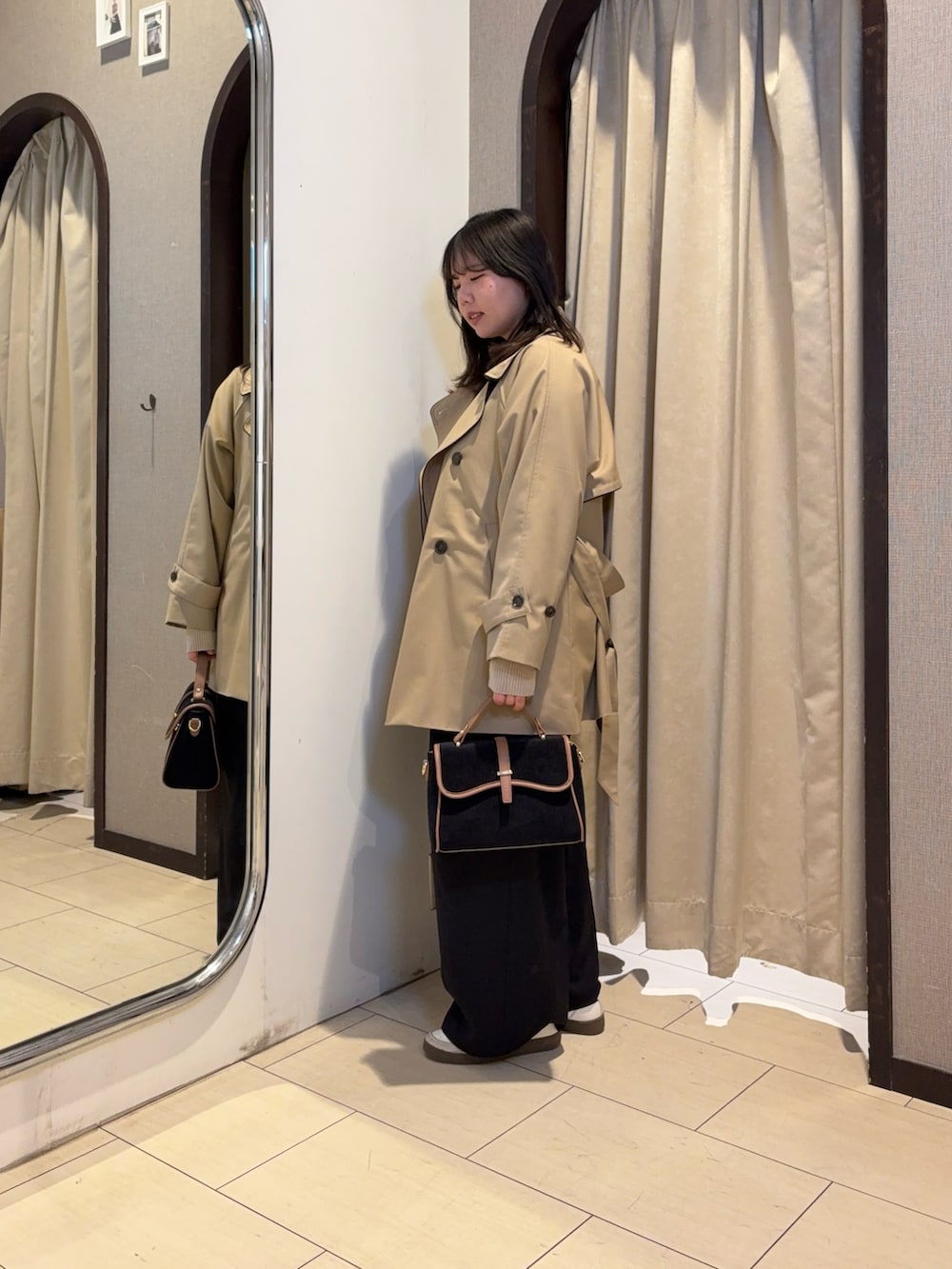 ベージュ系のカーディガン/ボレロ、ブラック系のその他パンツ、ベージュ系のトレンチコートを着用したレディースの冬コーディネートの2枚目の写真