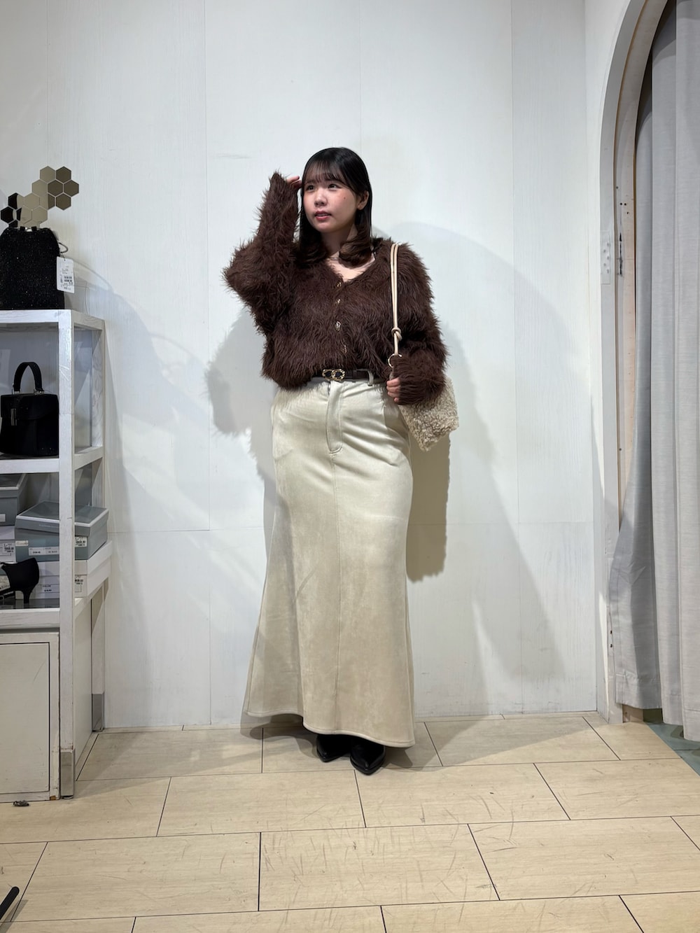 ベージュ系のスカート、ブラック系のブーツ、ブラウン系のカーディガン/ボレロを着用したレディースの秋コーディネートの3枚目の写真