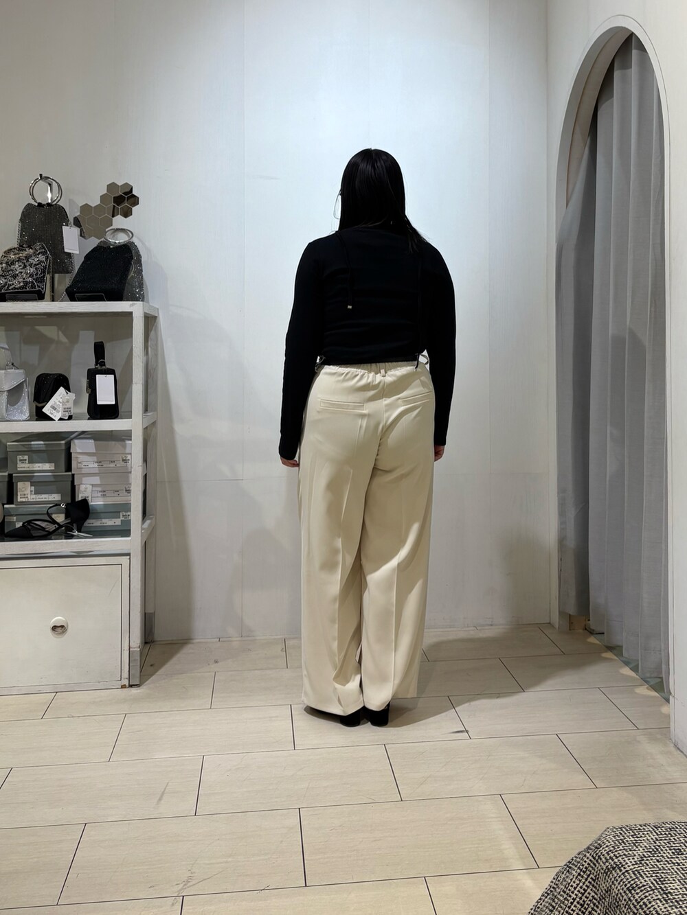 ホワイト系のスラックス、ブラック系のTシャツ/カットソー、ブラック系のベルトを着用したレディースの秋コーディネートの3枚目の写真