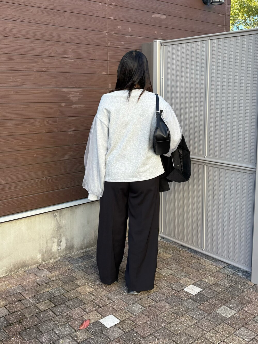 グレー系のTシャツ/カットソー、ブラック系のスラックスを着用したレディースの秋コーディネートの3枚目の写真