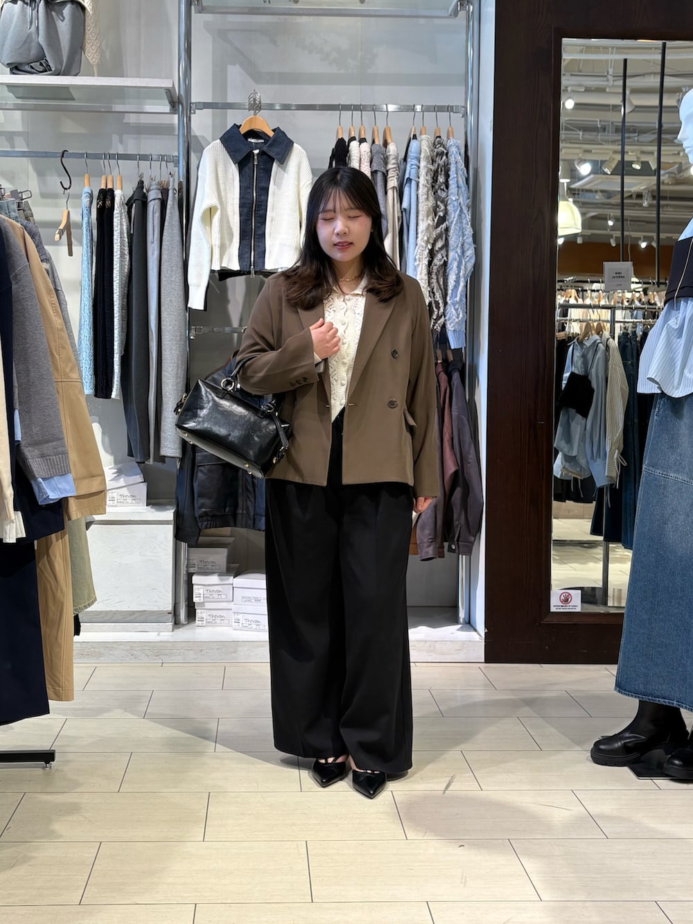 ホワイト系のカーディガン/ボレロ、ブラウン系のテーラードジャケット、ブラック系のパンプスを着用したレディースの春コーディネートの3枚目の写真