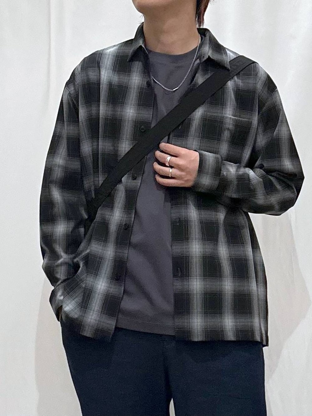 ブラック系のショルダーバッグ、ブラック系のシャツ/ブラウス、グレー系のTシャツ/カットソーを着用したメンズの春コーディネートの2枚目の写真