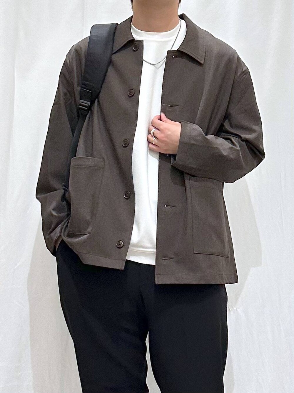 ブラック系のバックパック/リュック、ホワイト系のTシャツ/カットソー、ブラウン系のシャツ/ブラウスを着用したメンズの冬コーディネートの2枚目の写真