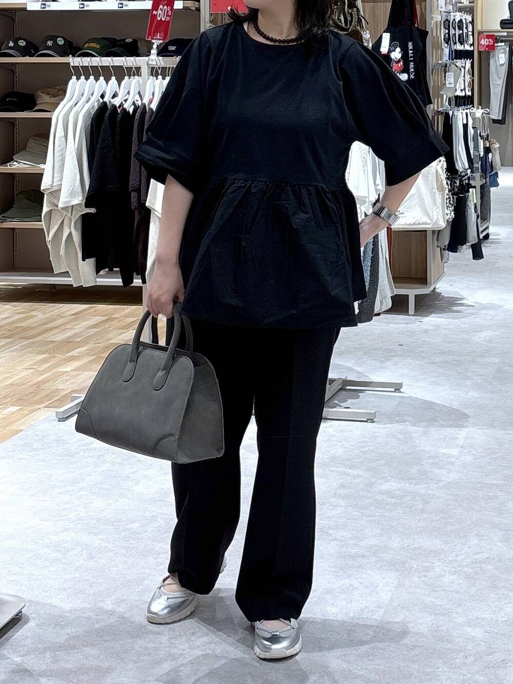 グレー系のスニーカー、ブラック系のスラックス、グリーン系のショルダーバッグを着用したレディースの秋コーディネートの5枚目の写真