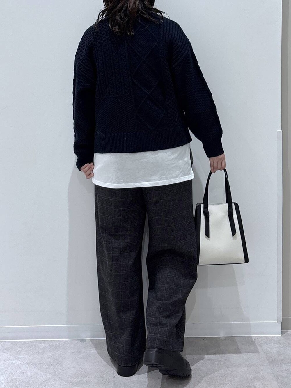 ホワイト系のショルダーバッグ、ホワイト系のTシャツ/カットソー、ブラック系のブーツを着用したレディースの秋コーディネートの3枚目の写真