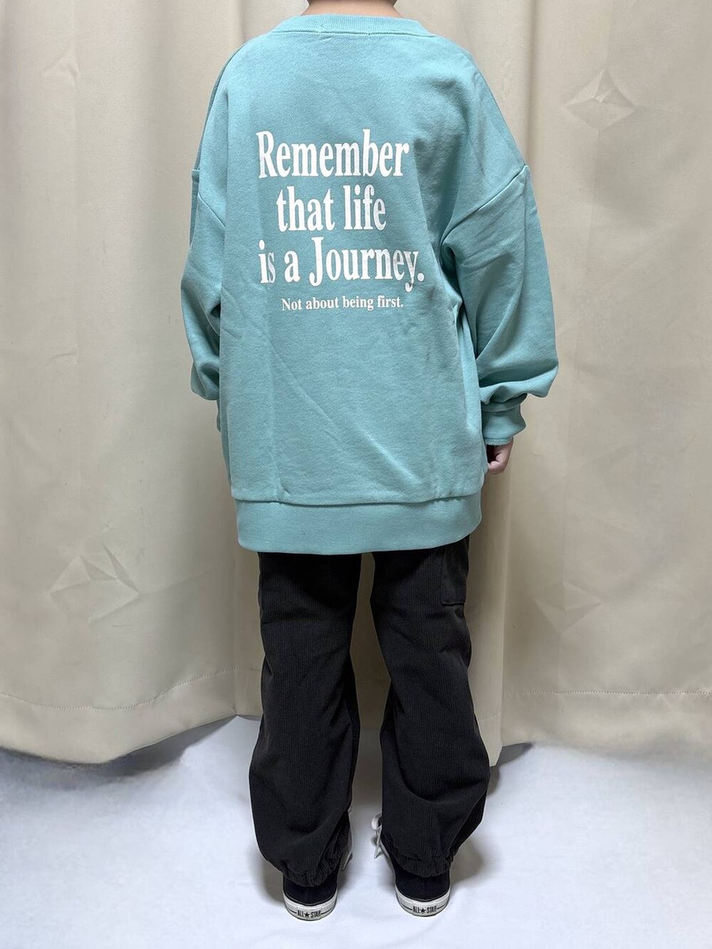 グリーン系のスウェット、グレー系のカーゴパンツを着用したキッズの秋コーディネートの3枚目の写真