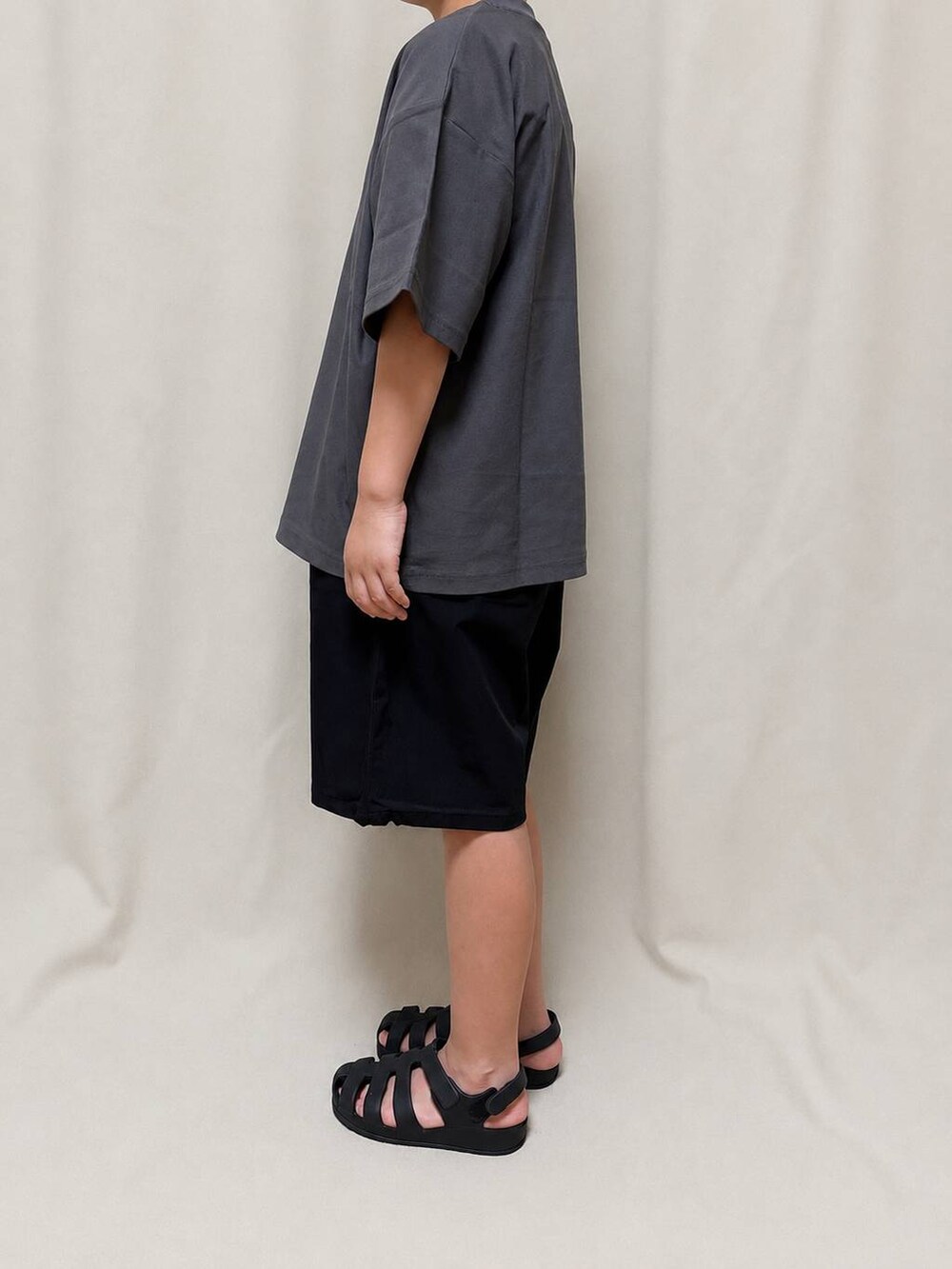 ブラック系のその他パンツ、グレー系のTシャツ/カットソーを着用したキッズの夏コーディネートの2枚目の写真