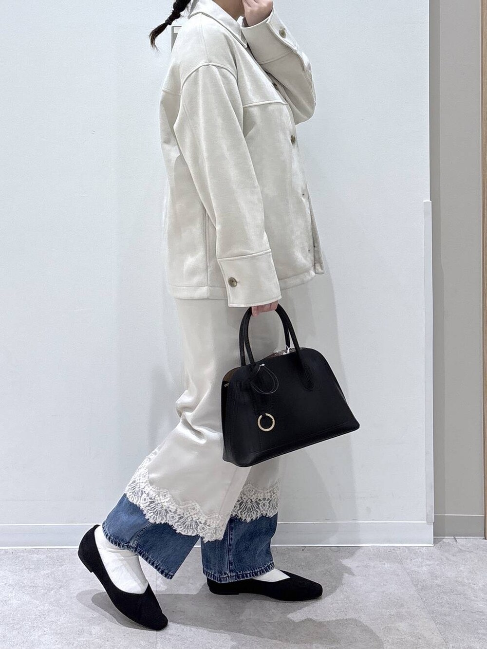 ブラック系のパンプス、ブラック系のショルダーバッグ、ベージュ系のテーラードジャケットを着用したレディースの春コーディネートの2枚目の写真