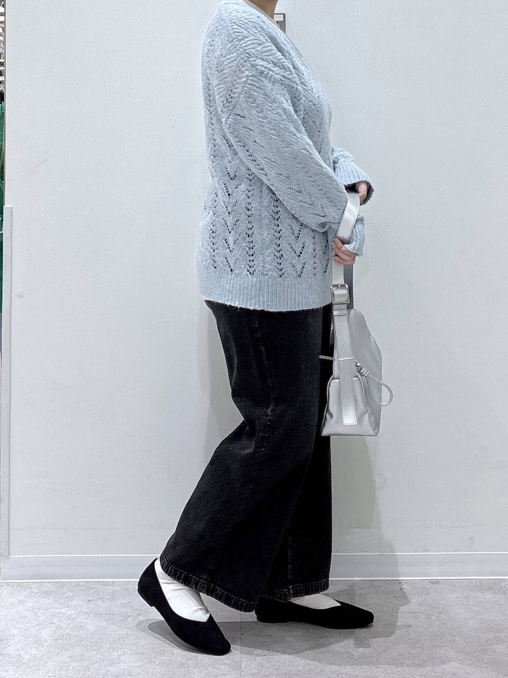 ブラック系のパンプス、ブラック系のデニムパンツ、ブルー系のニット/セーターを着用したレディースの冬コーディネートの2枚目の写真