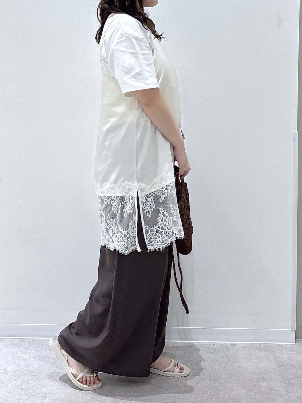 ブラウン系のその他パンツ、ホワイト系のTシャツ/カットソー、ブラウン系のクラッチバッグを着用したレディースの夏コーディネートの2枚目の写真